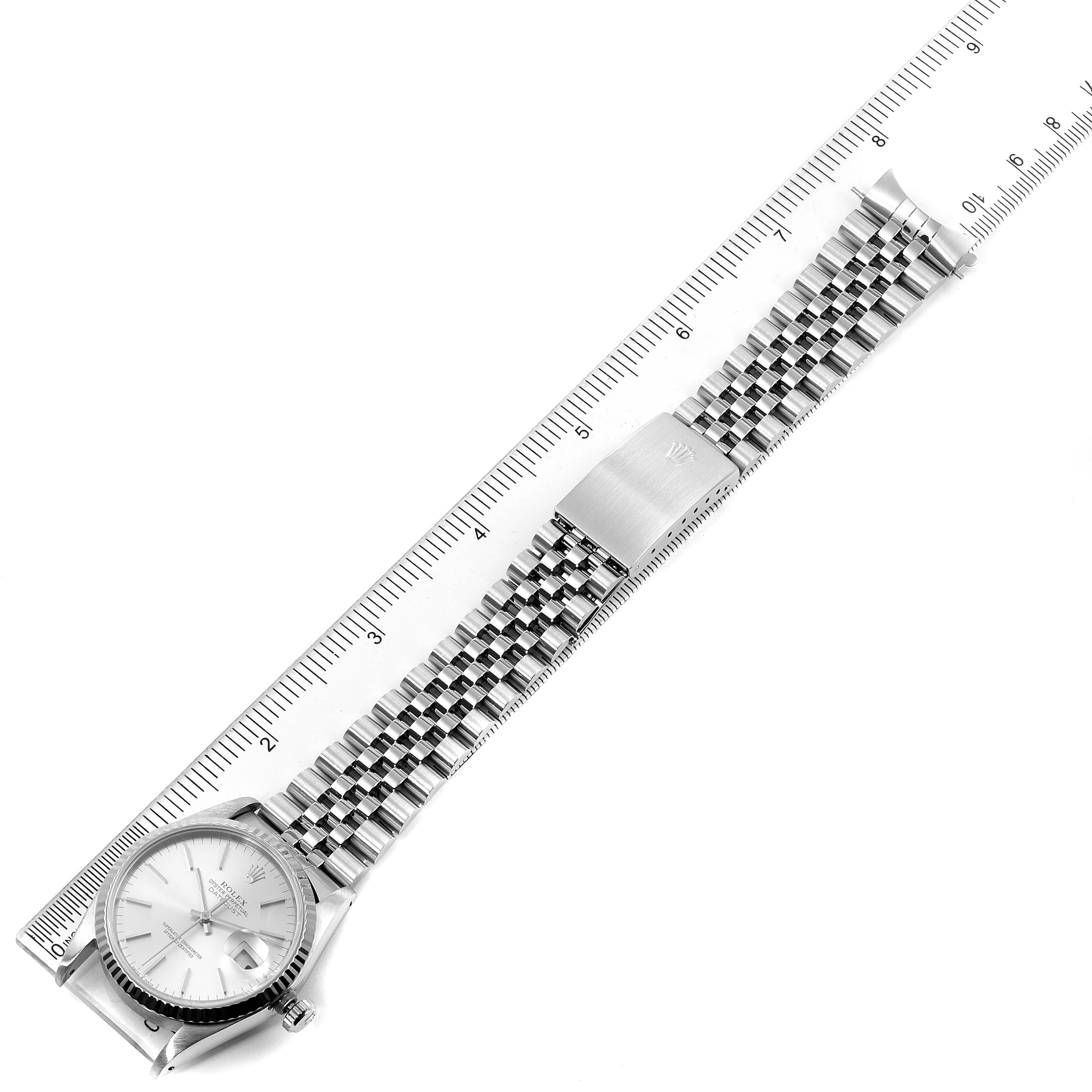 This image shows a Rolex Datejust 16234 Men's Stainless Steel Silver Dial 16234 Men's Stainless Steel Silver Dial watch laid flat next to a ruler, displaying the face, Jubilee bracelet, and clasp.