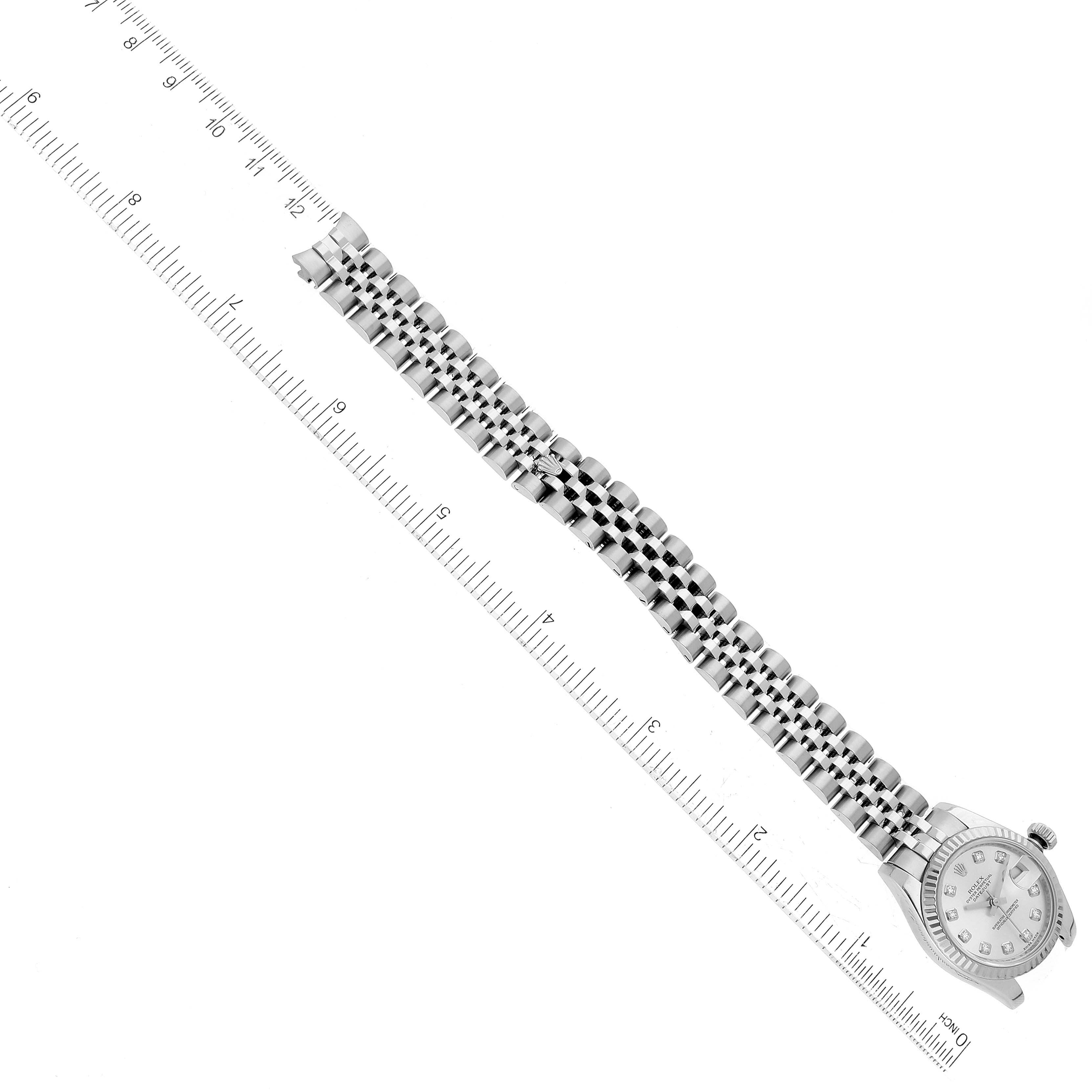 The image shows a Rolex Datejust 179174 Women's Stainless Steel Silver Dial 179174 Women's Stainless Steel Silver Dial watch from a top-down angle, highlighting the face and extended metal bracelet alongside a ruler for scale.