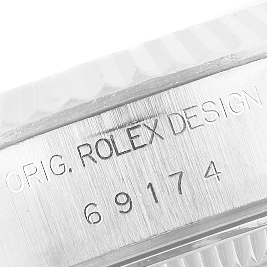 This image shows a close-up of the engraved case side of a Rolex Datejust 69174 Women
s Stainless Steel Silver Dial 69174 Women
s Stainless Steel Silver Dial watch with the model number and "ROLEX DESIGN" inscription.