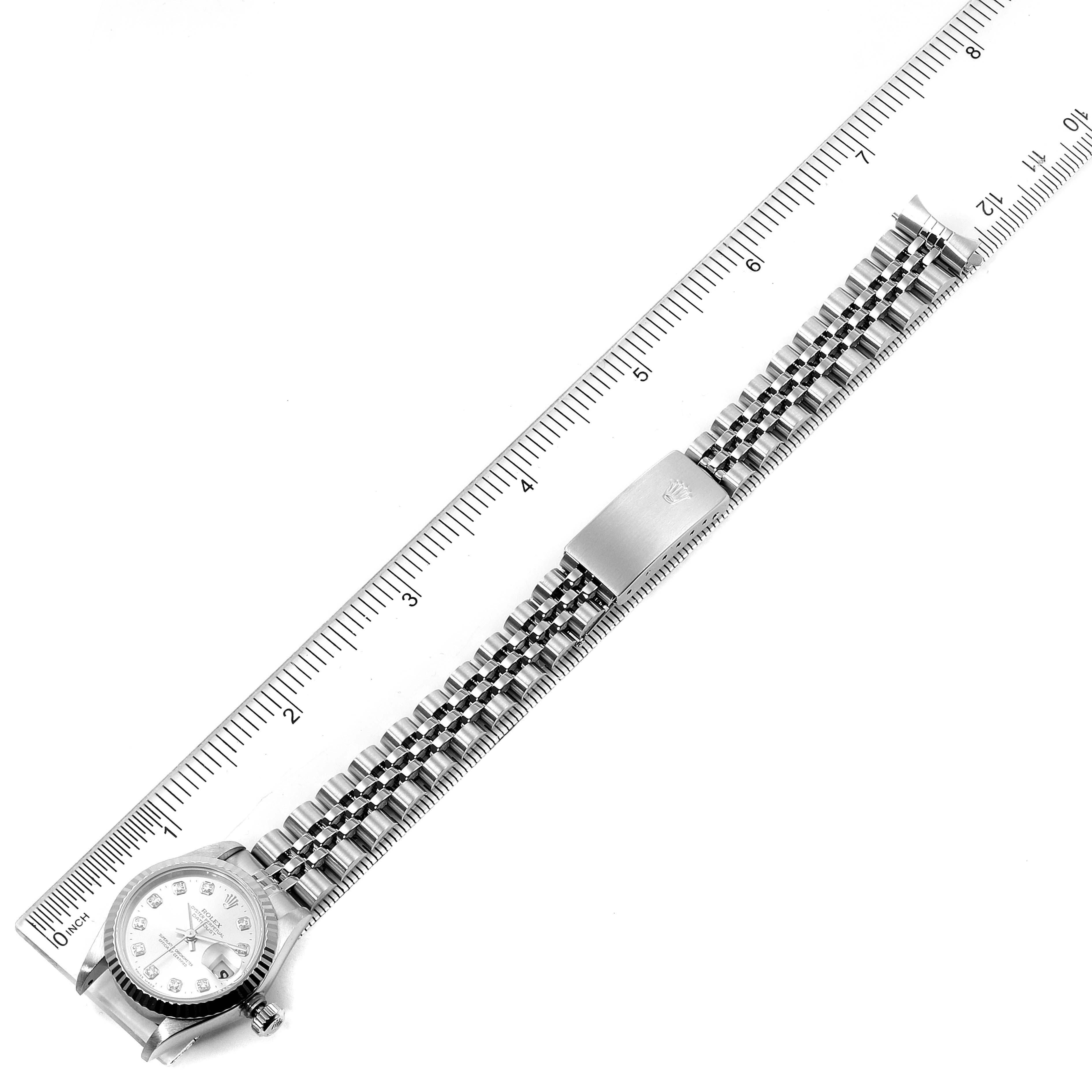 This image shows a Rolex Datejust 69174 Women
s Stainless Steel Silver Dial 69174 Women
s Stainless Steel Silver Dial watch laid flat with the face, crown, and full bracelet visible, aligned next to a ruler.