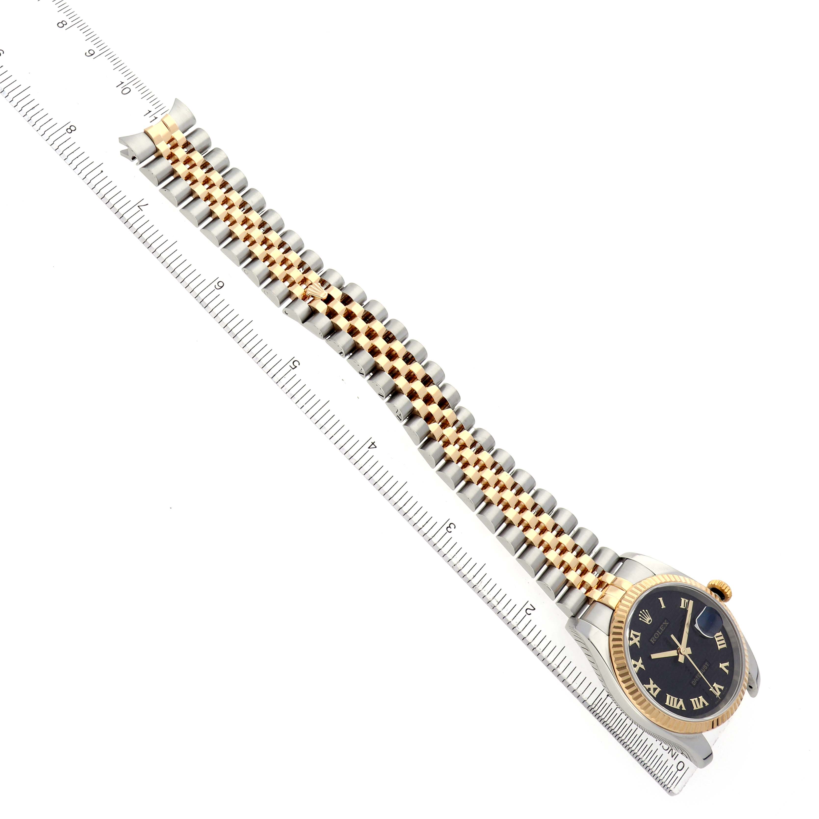 The Rolex Datejust 116233 Men's Steel and Gold (two tone) Black Dial watch is shown from an overhead angle, highlighting the band and face alongside a measurement scale.