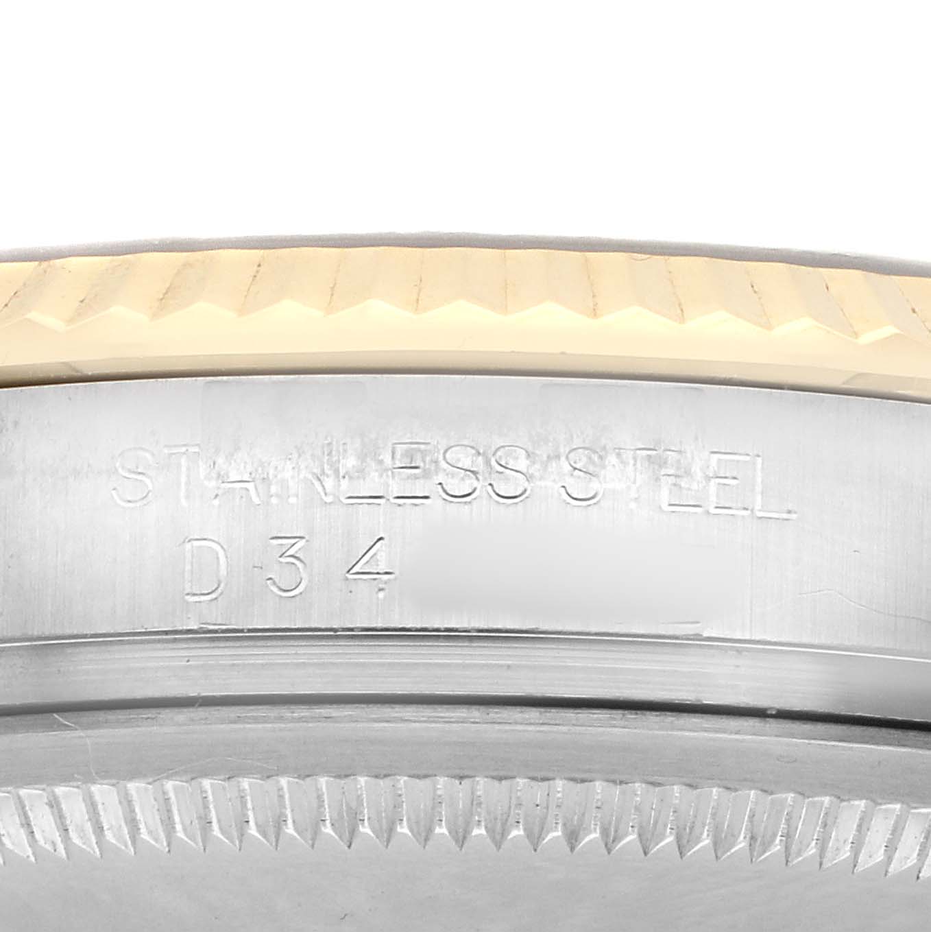 The image shows a close-up of the Rolex Datejust 116233 Men's Steel and Gold (two tone) Black Dial's fluted bezel with "Stainless Steel" engraving visible.