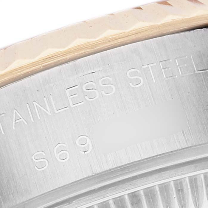 This close-up of a Rolex Datejust 69173G Women's Steel and Gold (two tone) White Dial 69173G Women's Steel and Gold (two tone) White Dial watch shows part of the bezel and the edge with engraved text.