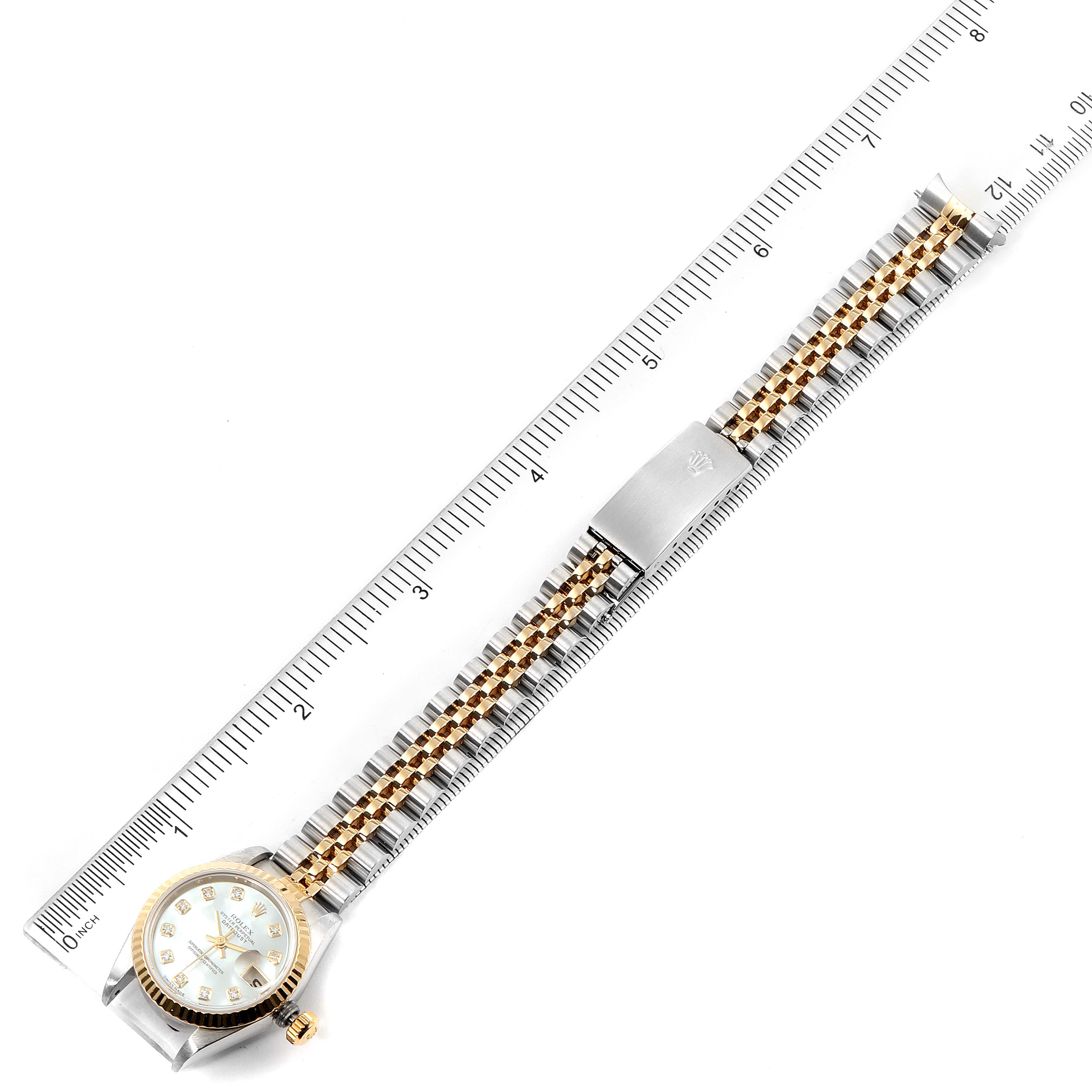The image shows the entire Rolex Datejust 79173 Women
s Steel and Gold (two tone) Mother of Pearl Dial 79173 Women
s Steel and Gold (two tone) Mother of Pearl Dial watch stretched out against a ruler, displaying the case, band, and clasp.