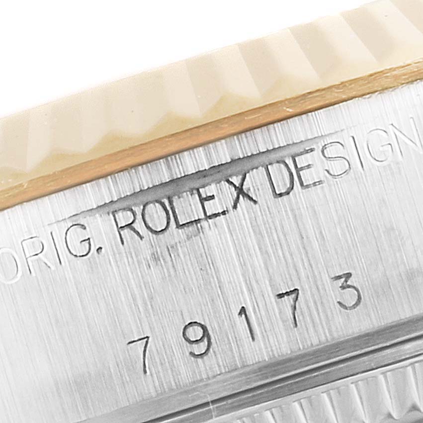 The image shows a close-up angle of the bezel and engravings on the side of a Rolex Datejust 79173 Women
s Steel and Gold (two tone) Mother of Pearl Dial 79173 Women
s Steel and Gold (two tone) Mother of Pearl Dial watch case.