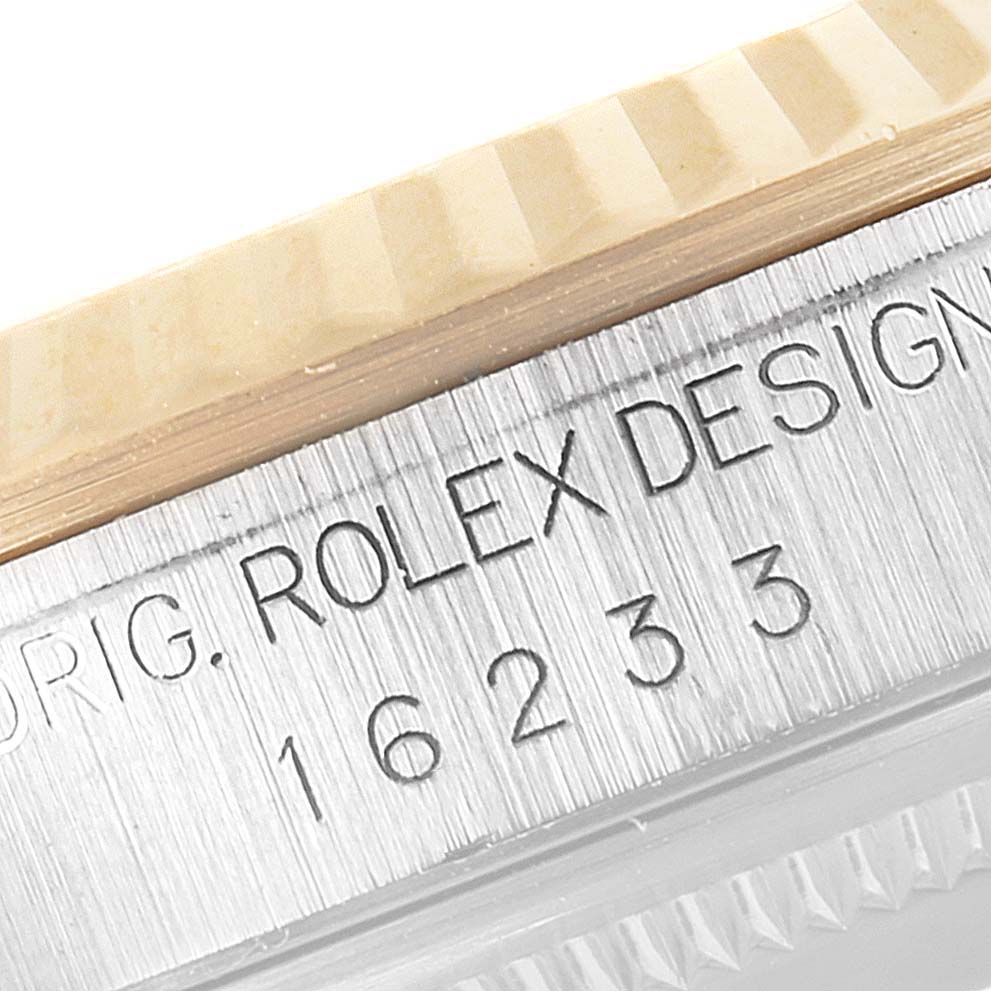 This image shows a close-up of the model number "16233" and "ROLEX DESIGN" engraved on the side of a Rolex Datejust 16233 Men
s Steel and Gold (two tone) Grey Dial 16233 Men
s Steel and Gold (two tone) Grey Dial watch case.