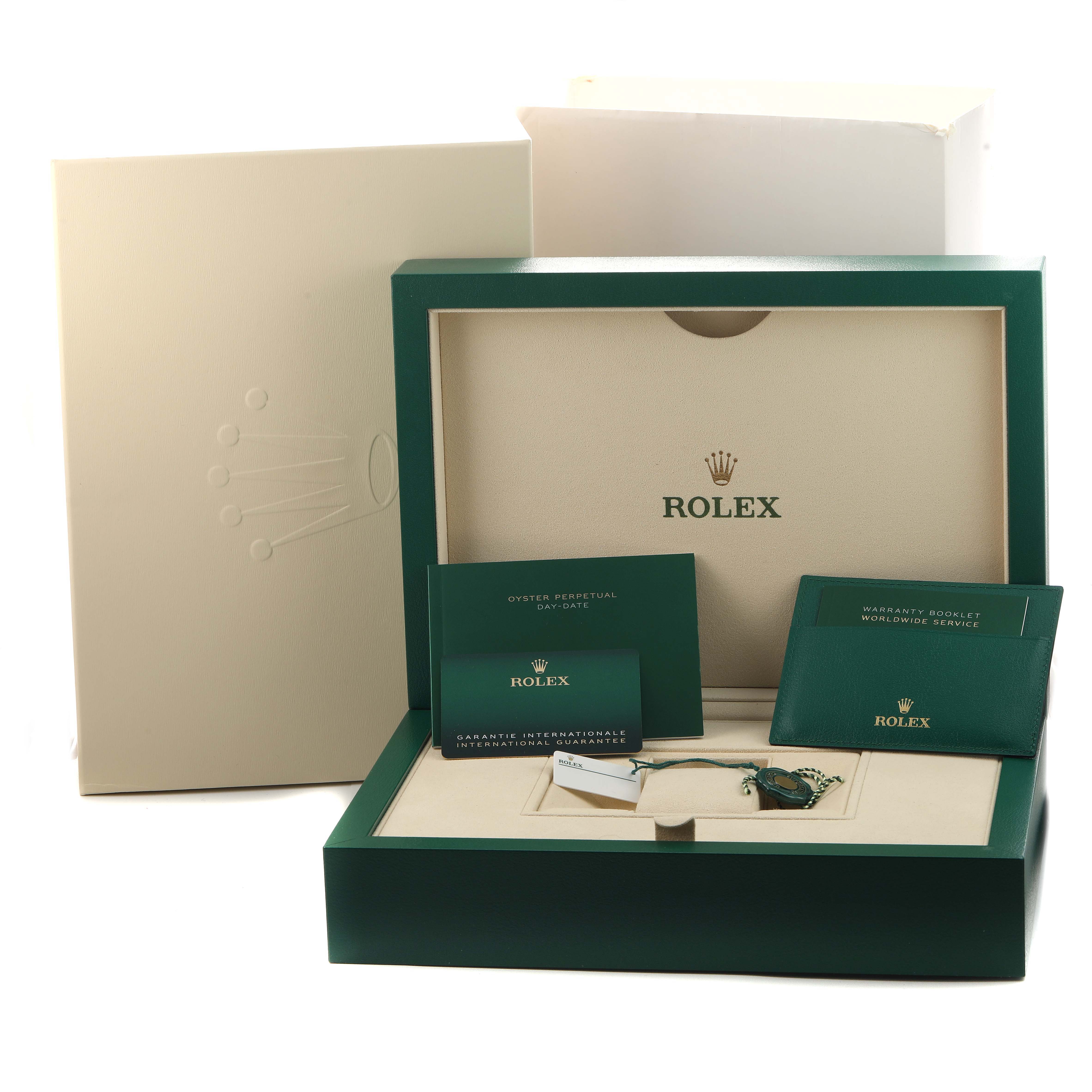 The image shows packaging and accessories for a Rolex President 228348 Men's Yellow Gold Champagne Dial model, including booklets and a tag, from a frontal angle.