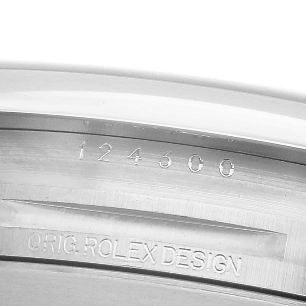 The image shows an engraved side of a Rolex Oyster Perpetual 124300 Men's Stainless Steel Blue Dial watch case with the model number "124300" and "ORIG. ROLEX DESIGN".