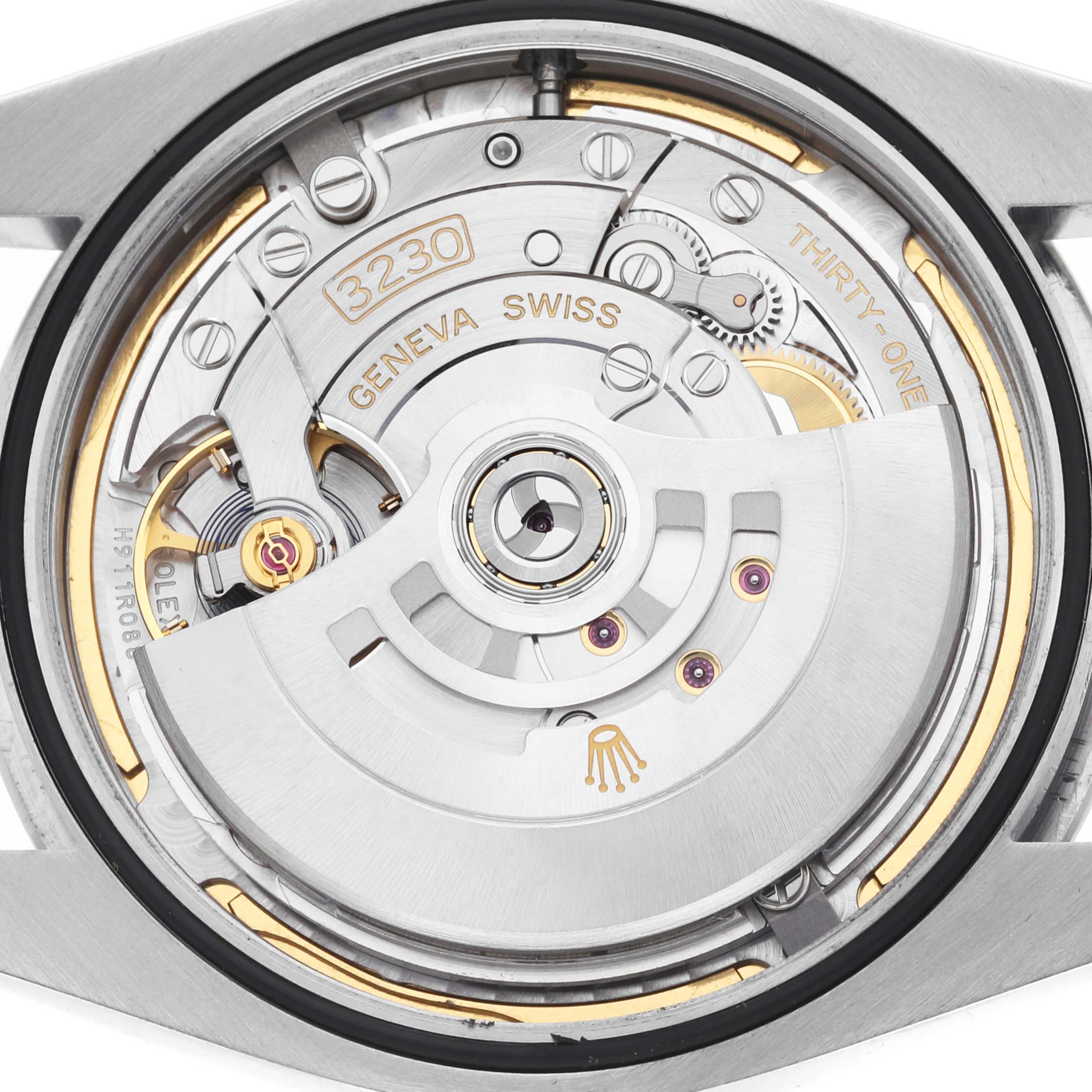 The image shows a close-up view of the movement inside a Rolex Oyster Perpetual 124300 Men's Stainless Steel Blue Dial watch, highlighting the rotor and intricate components.