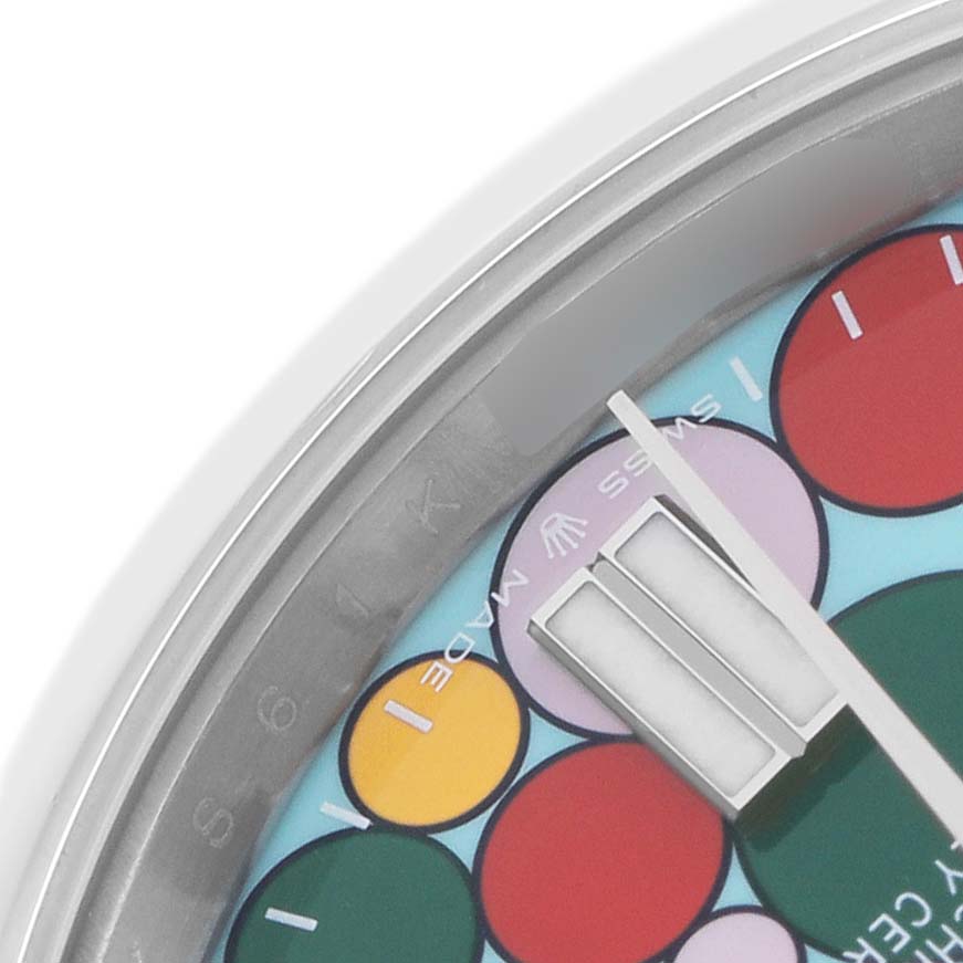 This image shows a close-up of the dial of a Rolex Oyster Perpetual 124300 Men's Stainless Steel Blue Dial watch, featuring colorful circles and partial hour markers.