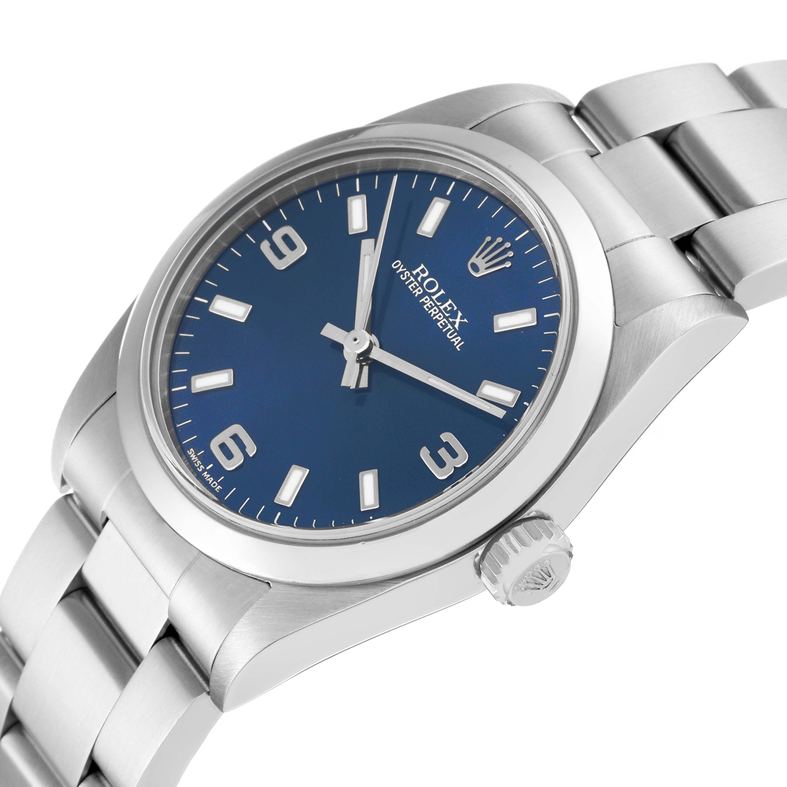 This Rolex Mid-Size 77080 Women
s Stainless Steel Blue Dial 77080 Women
s Stainless Steel Blue Dial Oyster Perpetual watch is shown at a three-quarter angle, highlighting its case, dial, and bracelet.
