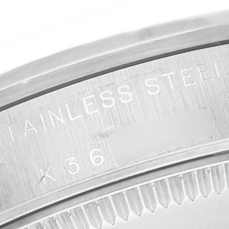 The image shows a close-up of the casing edge and part of the engraving on the Mid-Size Rolex watch.