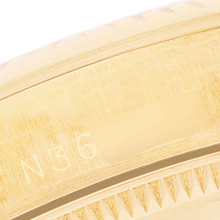 This close-up image shows a partial view of the bezel and serial number of a Rolex President 67518 Women
s Yellow Gold White Dial 67518 Women
s Yellow Gold White Dial model watch.