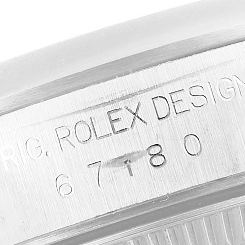 This image shows a partial side view of a Rolex Oyster Perpetual 67180 Women
s Stainless Steel Pink Dial 67180 Women
s Stainless Steel Pink Dial watch, highlighting the engraved "Rolex Design" and model number.