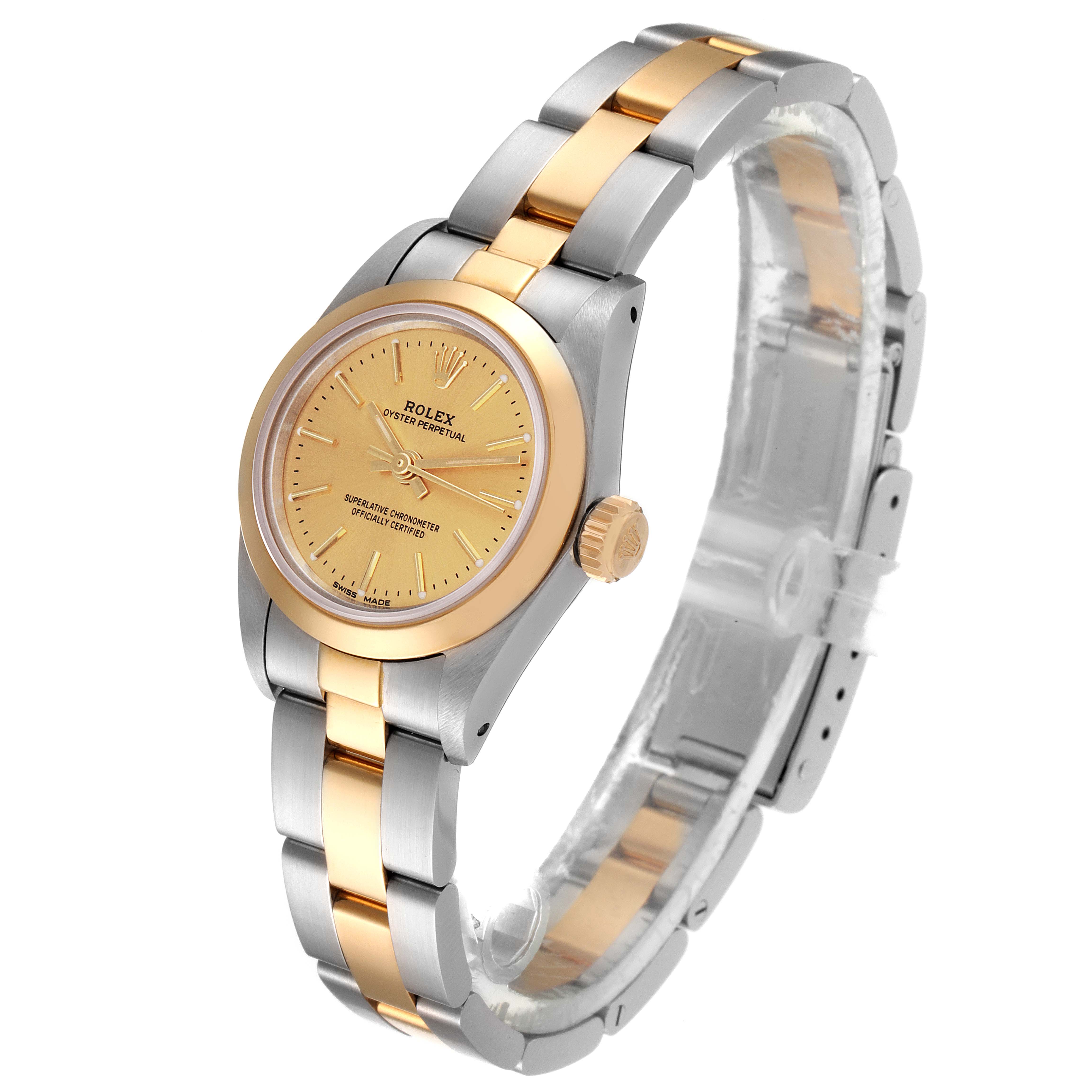 The image shows a Rolex Oyster Perpetual 67183 Women
s Steel and Gold (two tone) Champagne Dial 67183 Women
s Steel and Gold (two tone) Champagne Dial watch at a three-quarter angle, featuring a gold dial and a two-tone metal bracelet.