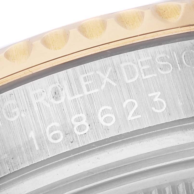 This close-up image shows the edge of the bezel and the casing of a Rolex Yacht-Master 168623 Men's Steel and Gold (two tone) White Dial 168623 Men's Steel and Gold (two tone) White Dial watch with the model number engraved.