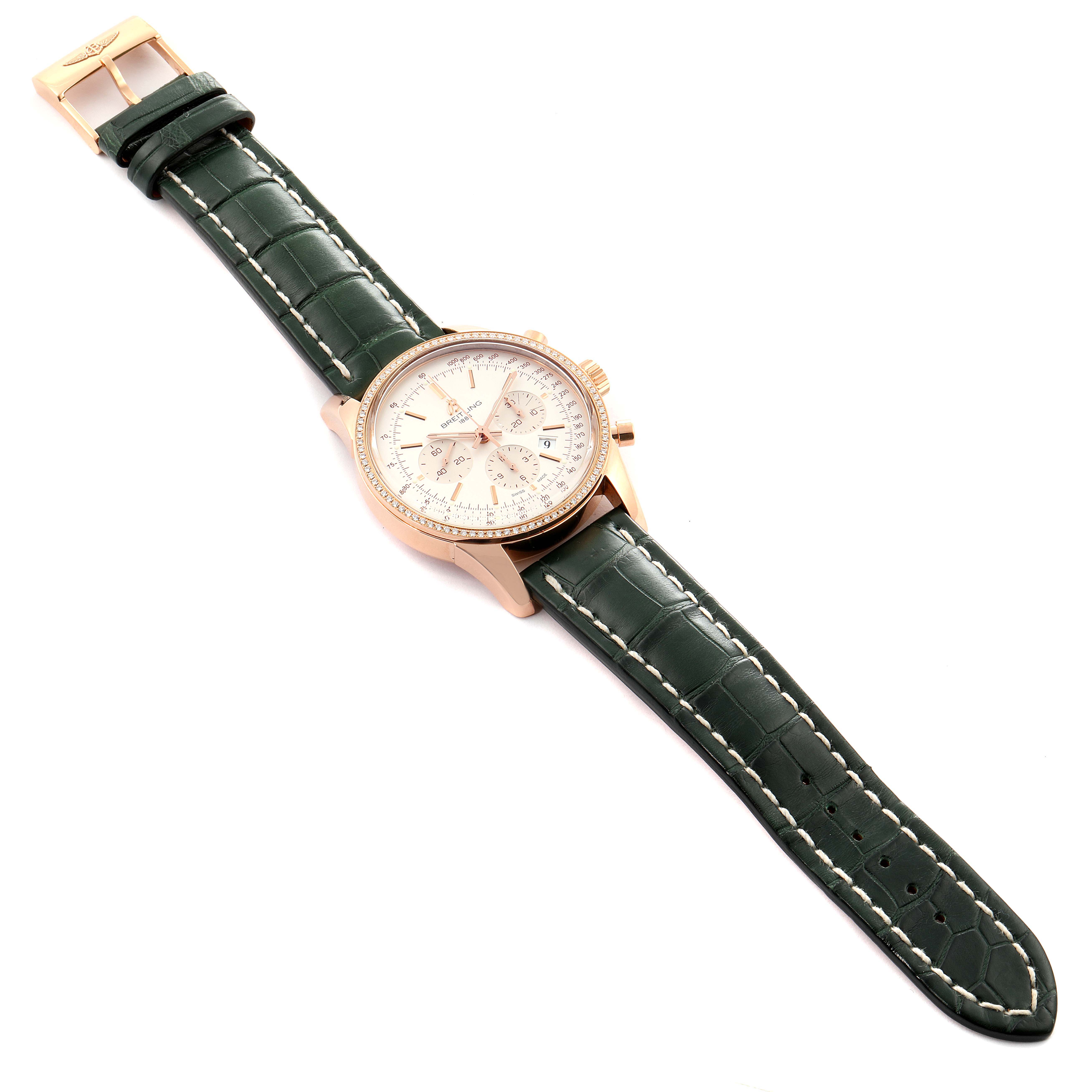 The image shows a Breitling Transocean RB0152 Men's Rose Gold Silver Dial RB0152 Men's Rose Gold Silver Dial watch at a slight angle, highlighting its green leather strap, rose gold case, and white dial.