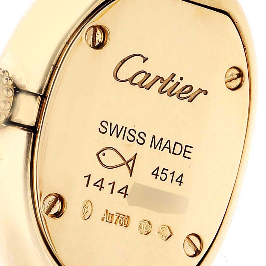 The image shows the back of a Cartier Baignoire WGBA0018 Women's Yellow Gold Silver Dial watch, featuring screws and engraving details.