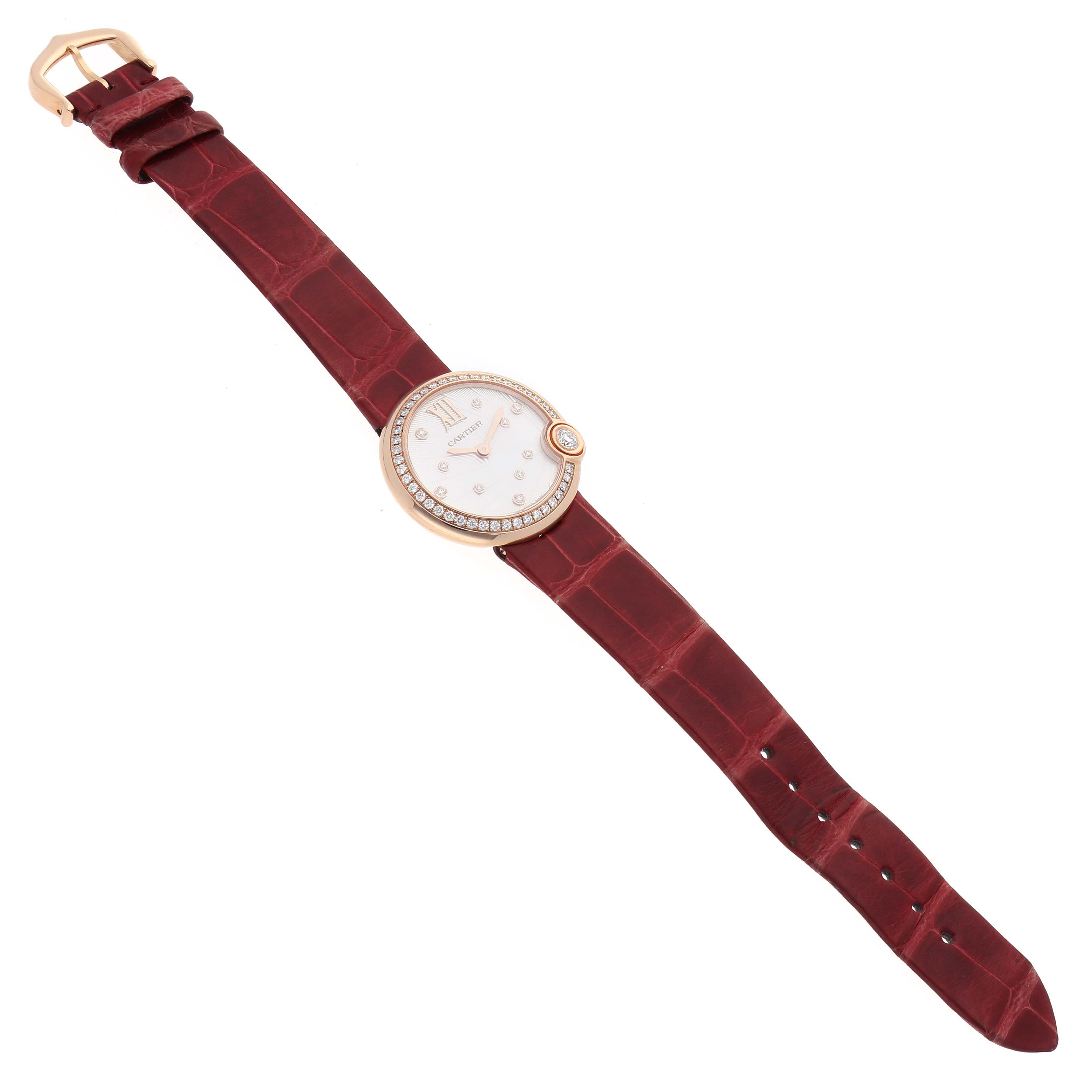The Cartier Ballon Blanc WJBL0012 Women's Rose Gold Silver Dial watch is shown from a top view, highlighting the face, bezel, and red leather strap.