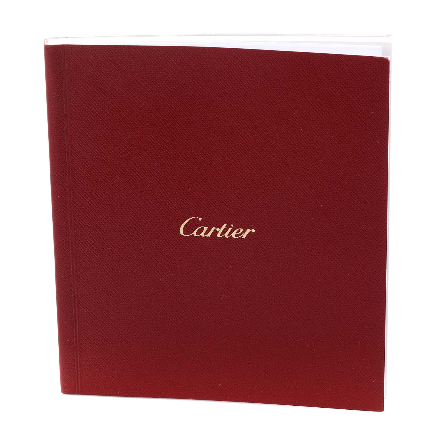 The image shows a red Cartier booklet with the brand name, likely an accessory for the Ronde model watch.
