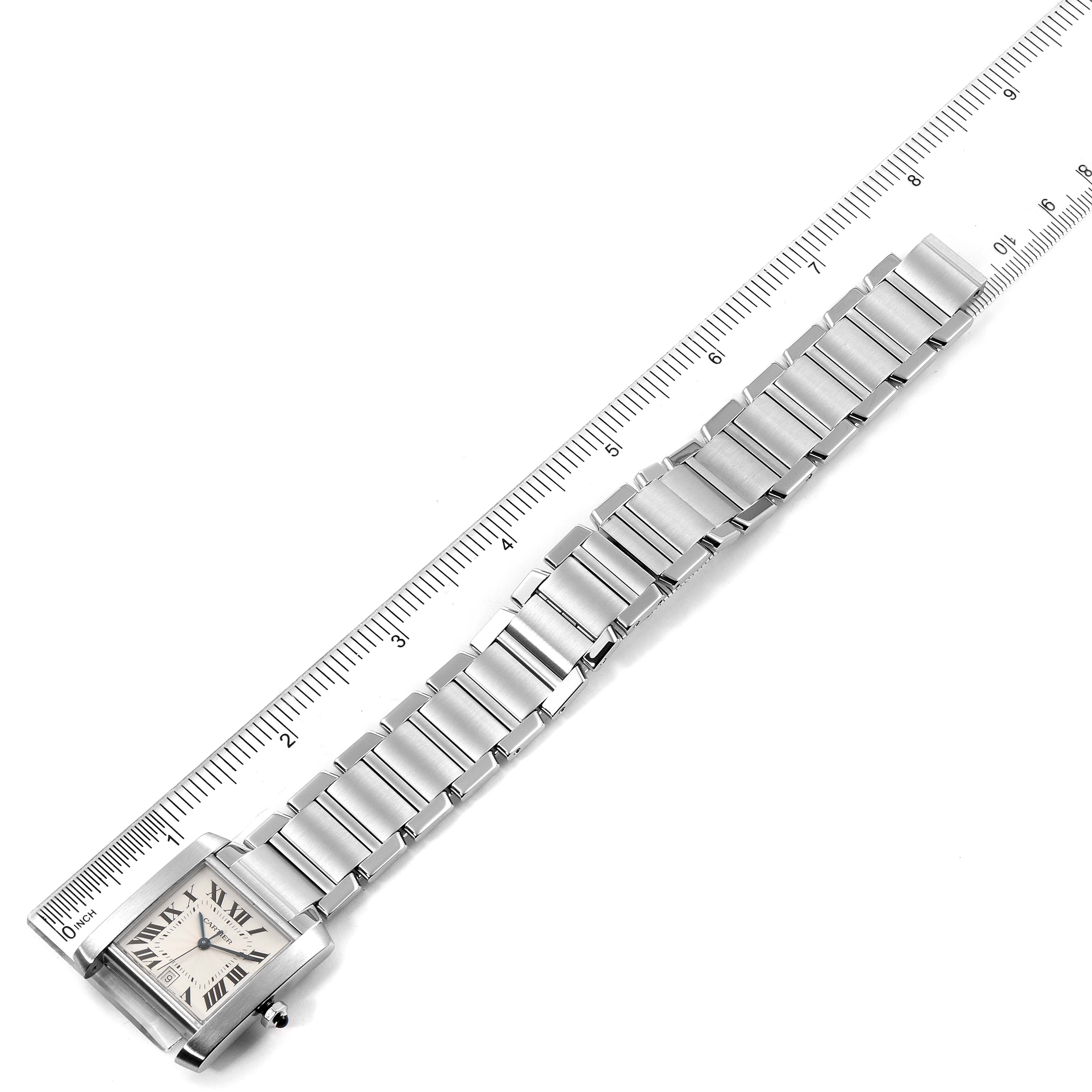 The image shows a Cartier Tank Francaise W51002Q3 Men's Stainless Steel Silver Dial W51002Q3 Men's Stainless Steel Silver Dial watch with a metal bracelet lying next to a ruler for scale, viewed from above.