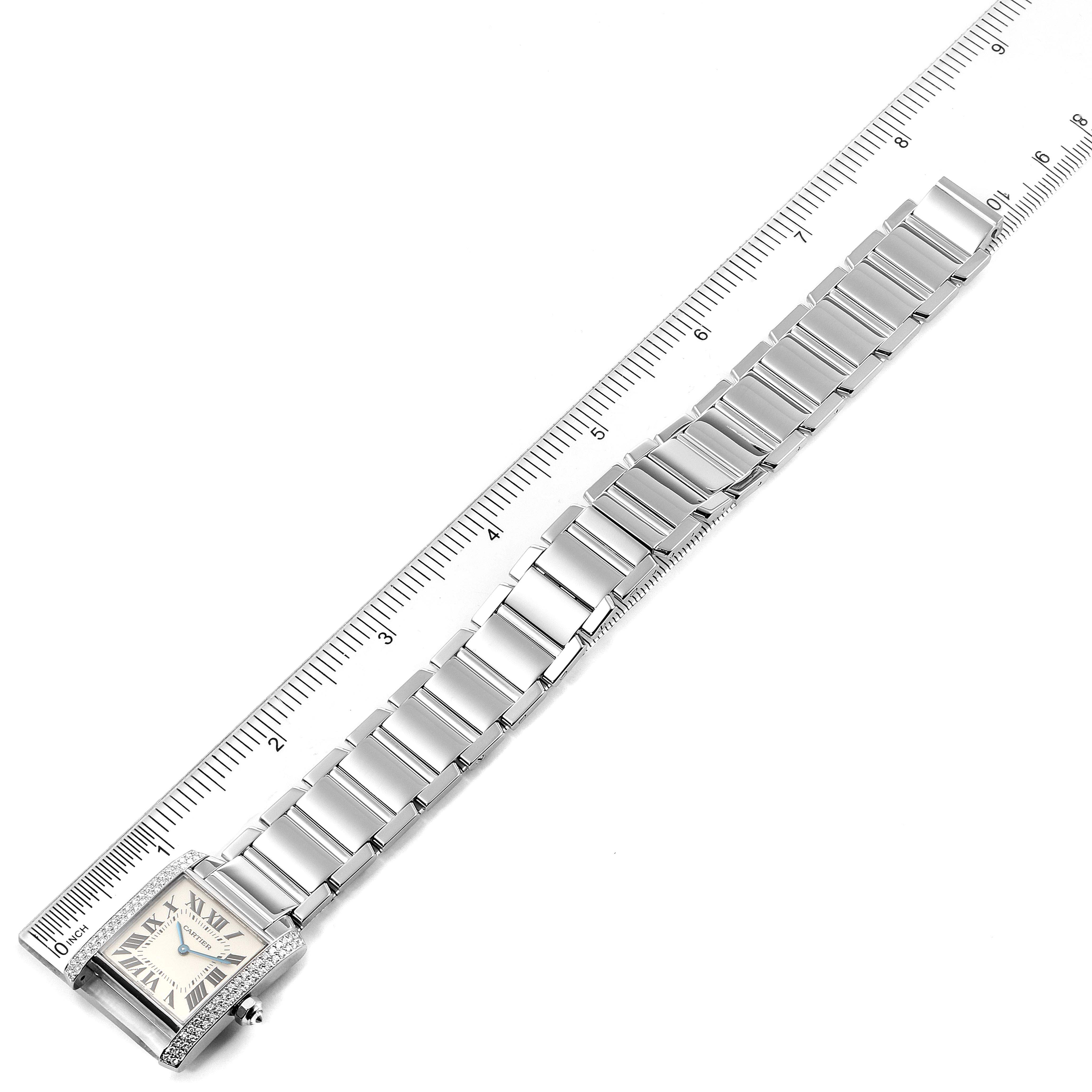 The image shows a top-down view of a Cartier Tank Francaise WE1009S3 Women's White Gold Silver Dial WE1009S3 Women's White Gold Silver Dial watch with a ruler beside it.