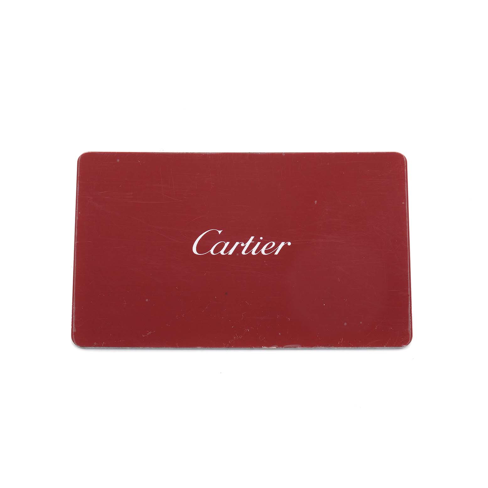 The image shows a red accessories card for Cartier's Tank Must model, with the brand name prominently displayed.