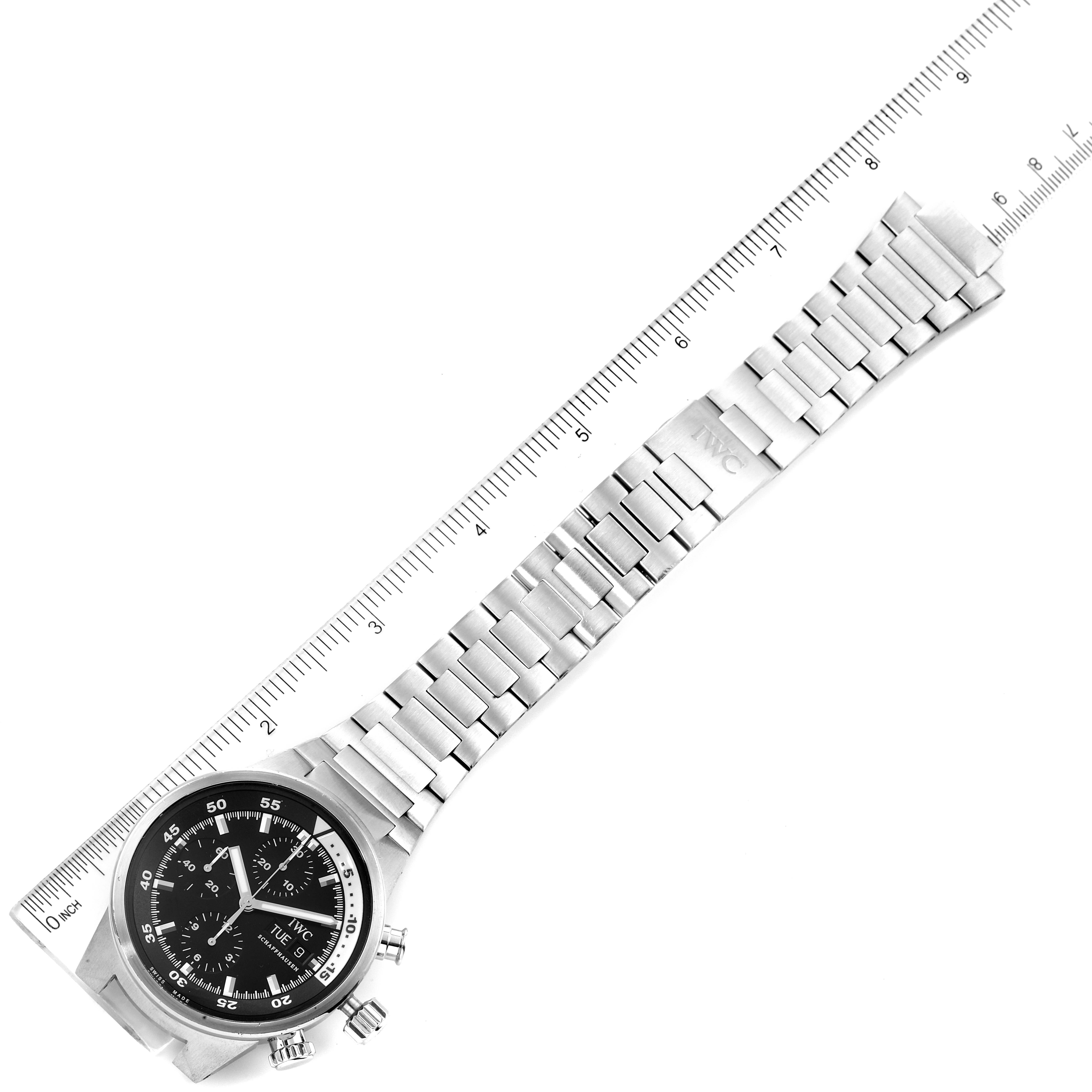 The IWC Aquatimer IW371928 Men's Stainless Steel Black Dial IW371928 Men's Stainless Steel Black Dial watch is shown from a top-down angle, highlighting the face, bezel, crown, and metal bracelet with a ruler for scale.