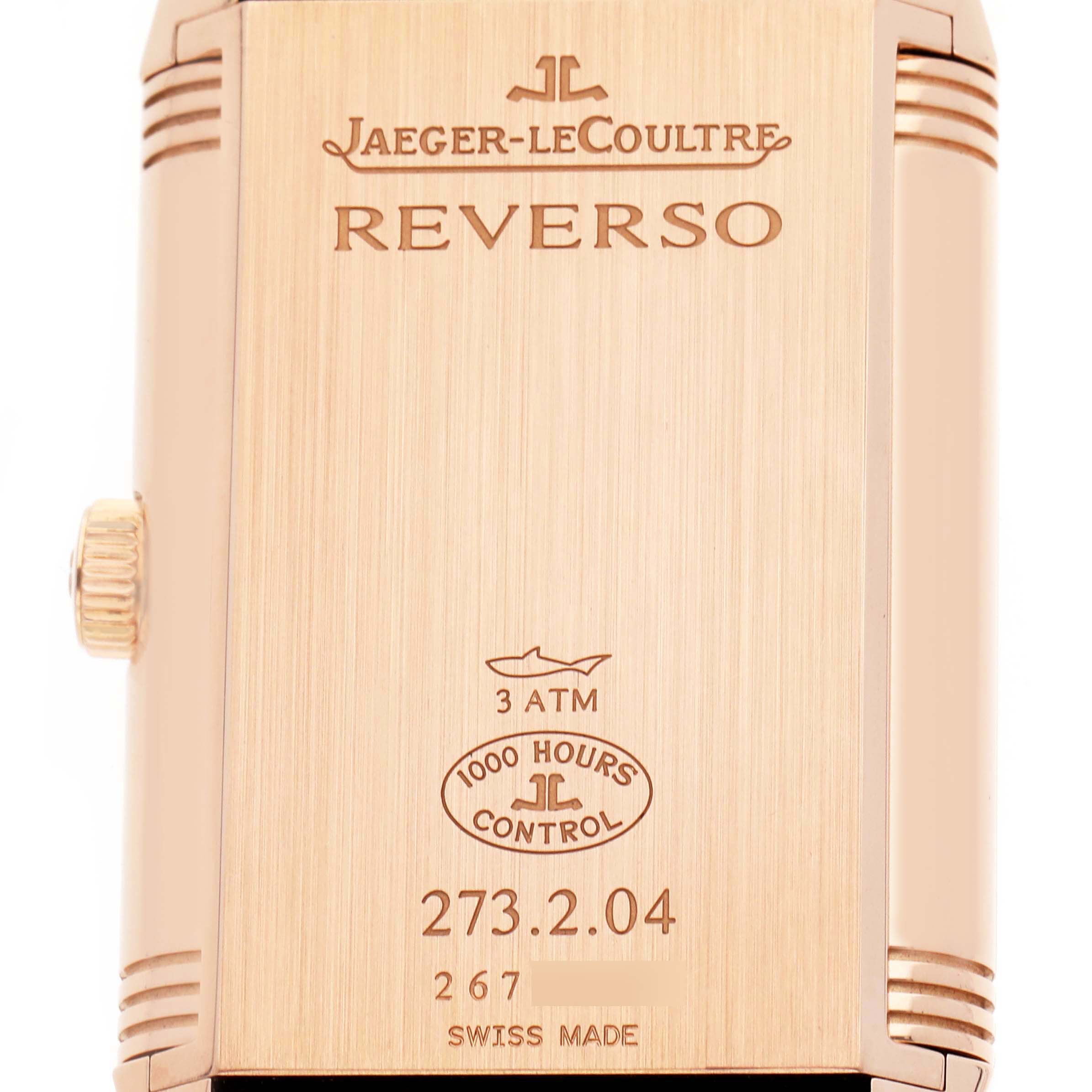 The image shows the back of a Jaeger-LeCoultre Reverso watch, highlighting its engravings and crown on the side.