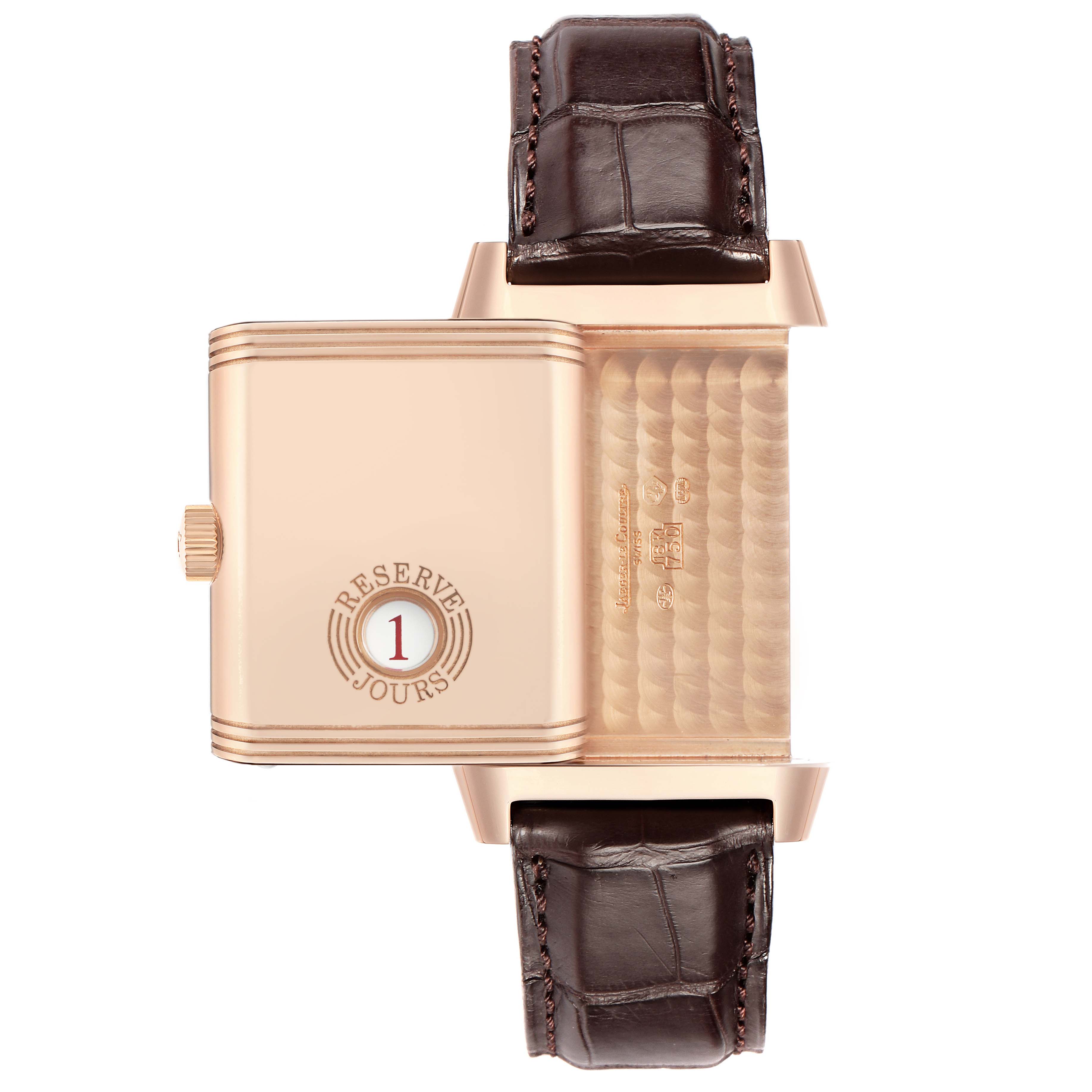 The Jaeger-LeCoultre Reverso watch is shown from a top view, highlighting the back case, crown, and leather strap.