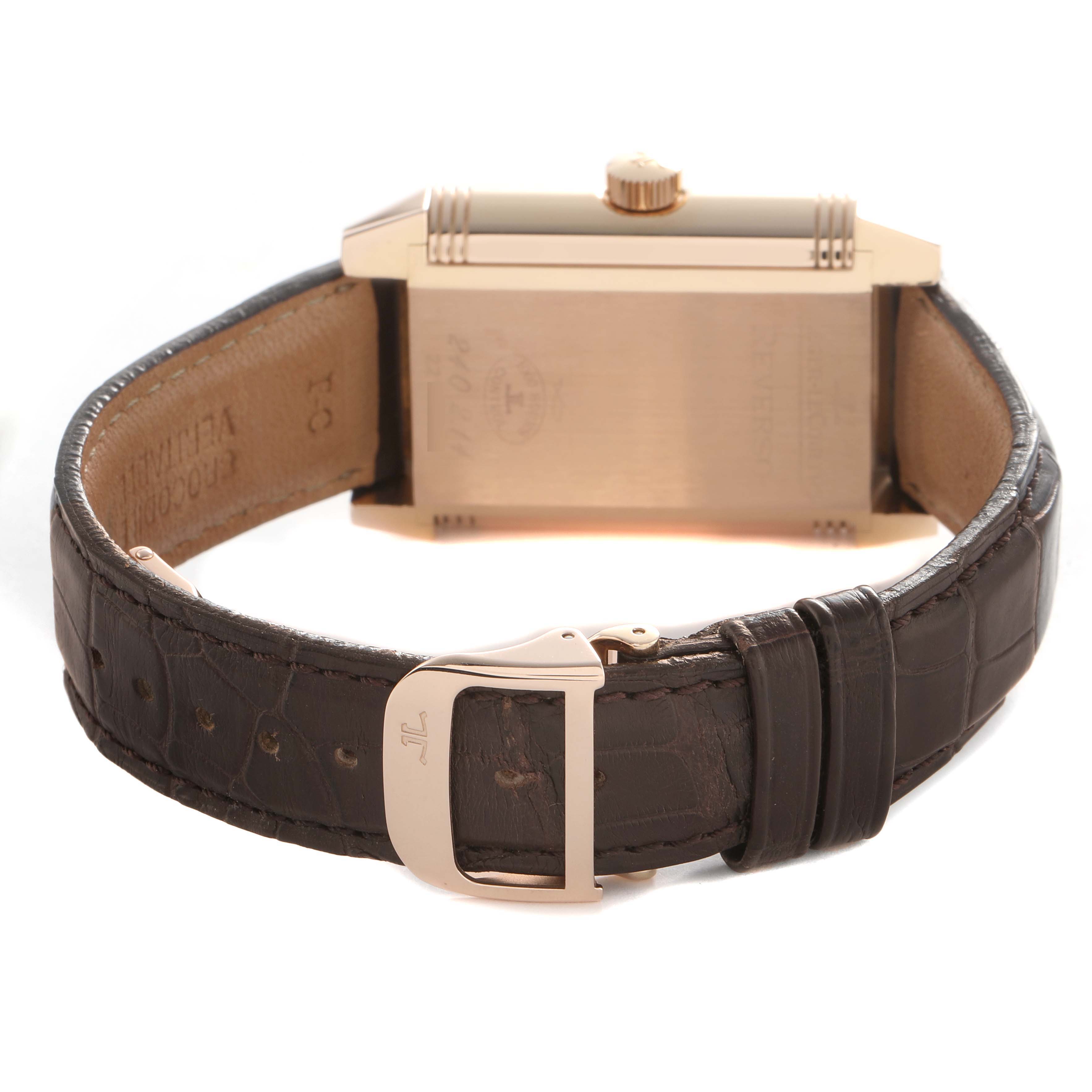 The image shows a Jaeger-LeCoultre Reverso watch from the back, highlighting the case, crown, and leather strap with a buckle.