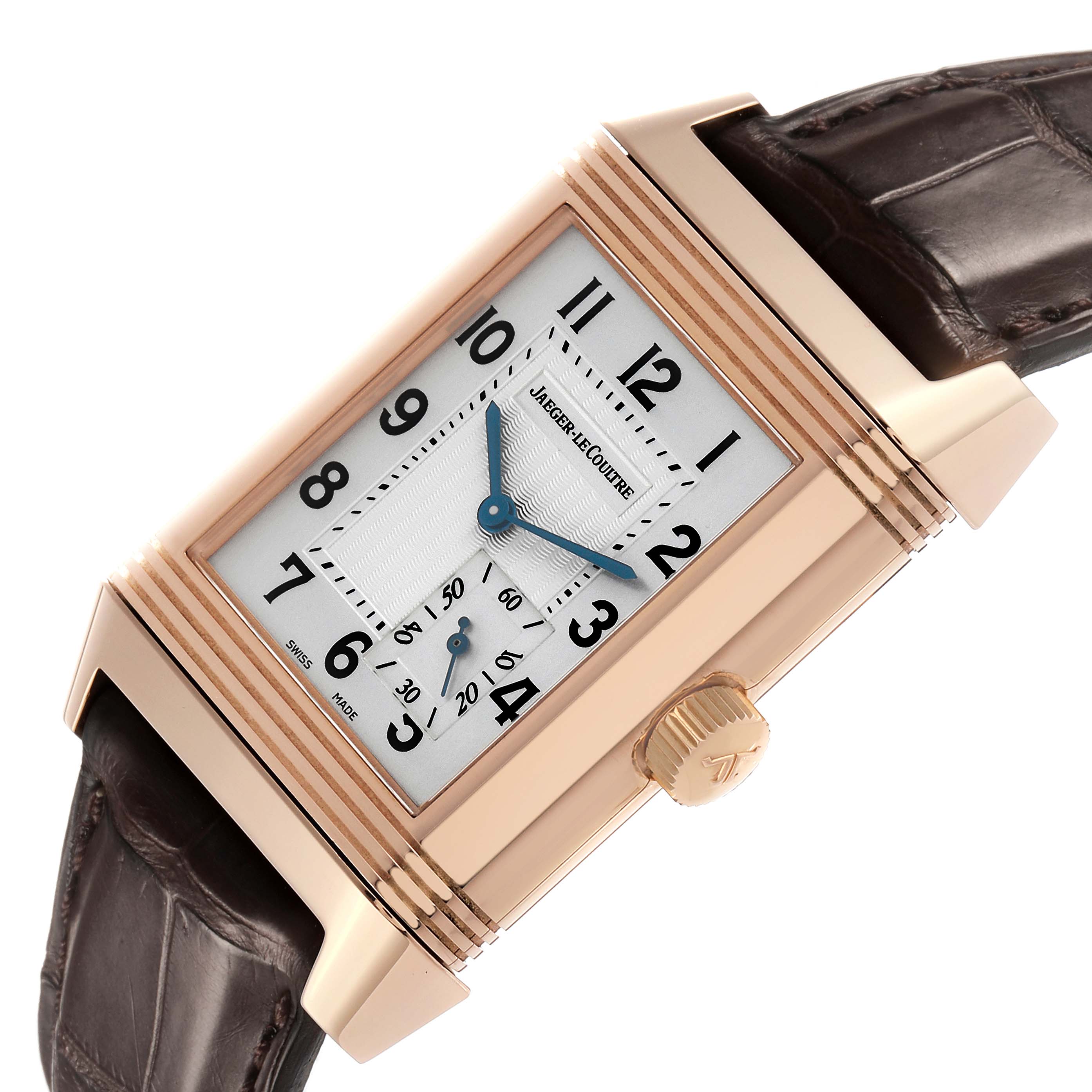 The Jaeger-LeCoultre Reverso watch is angled with its crown and brown leather strap visible.