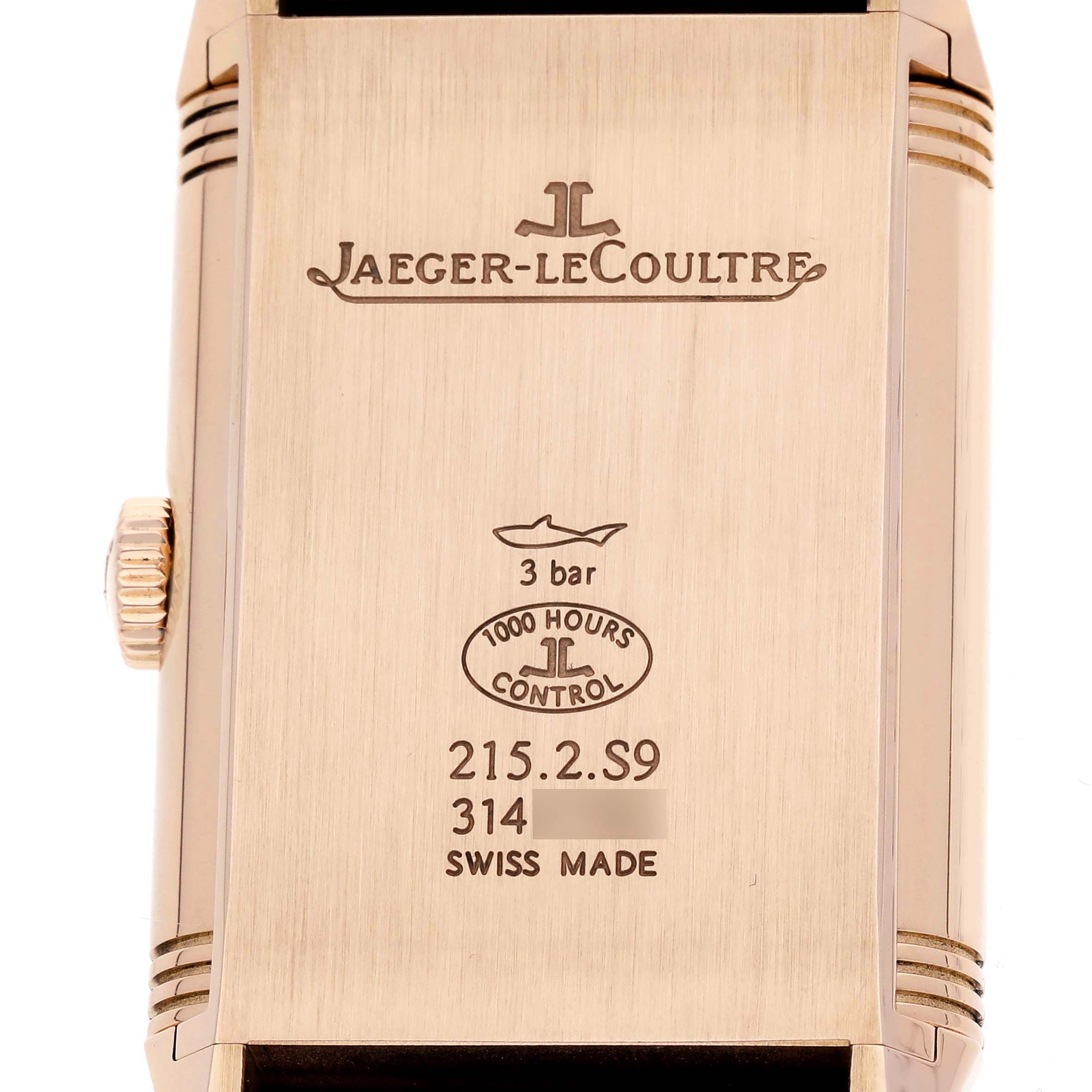 The image shows the back of a Jaeger-LeCoultre Reverso watch, highlighting brand engravings and the crown.