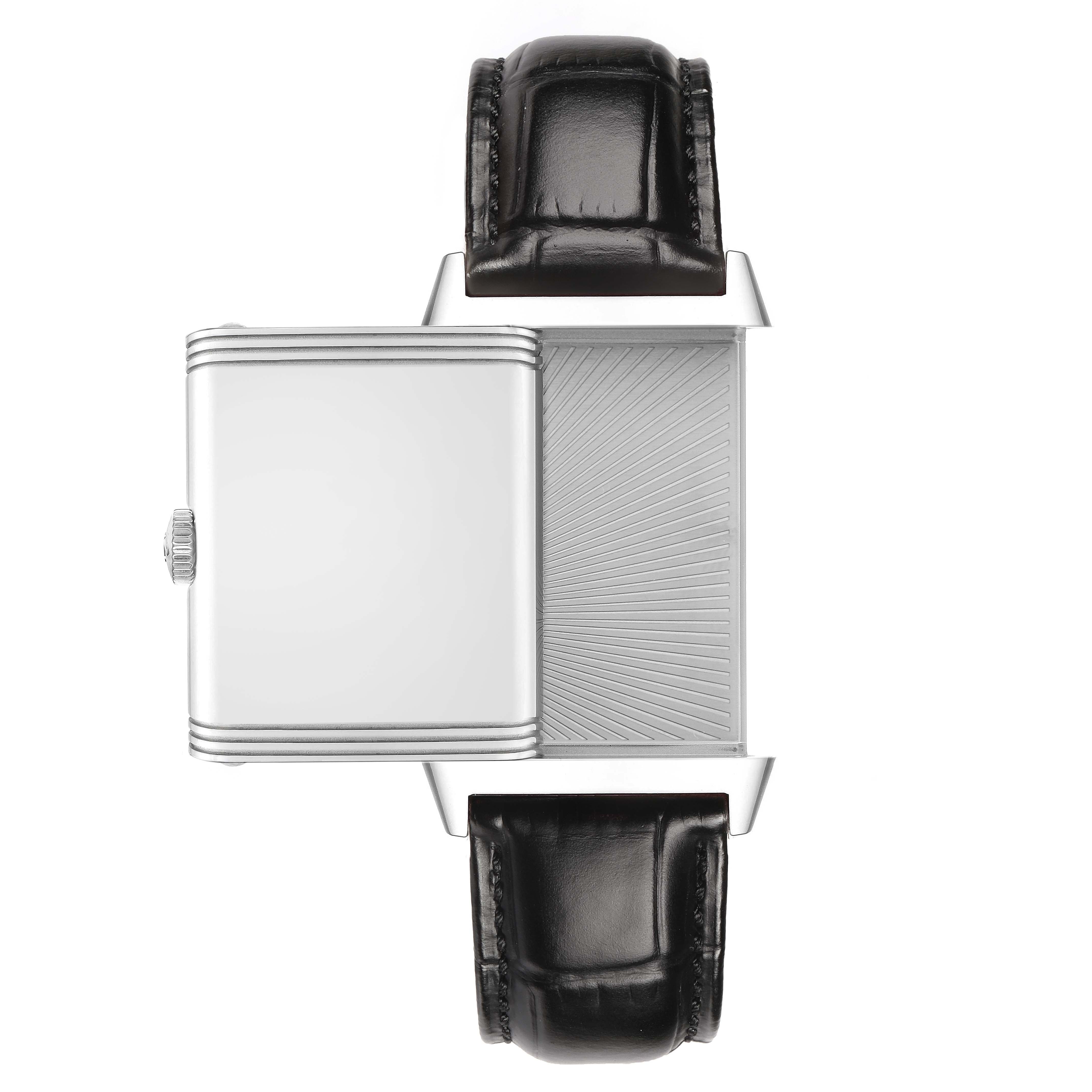The image shows a side view of a Jaeger-LeCoultre Reverso watch with its case swiveled open, revealing the back and parts of the leather strap.