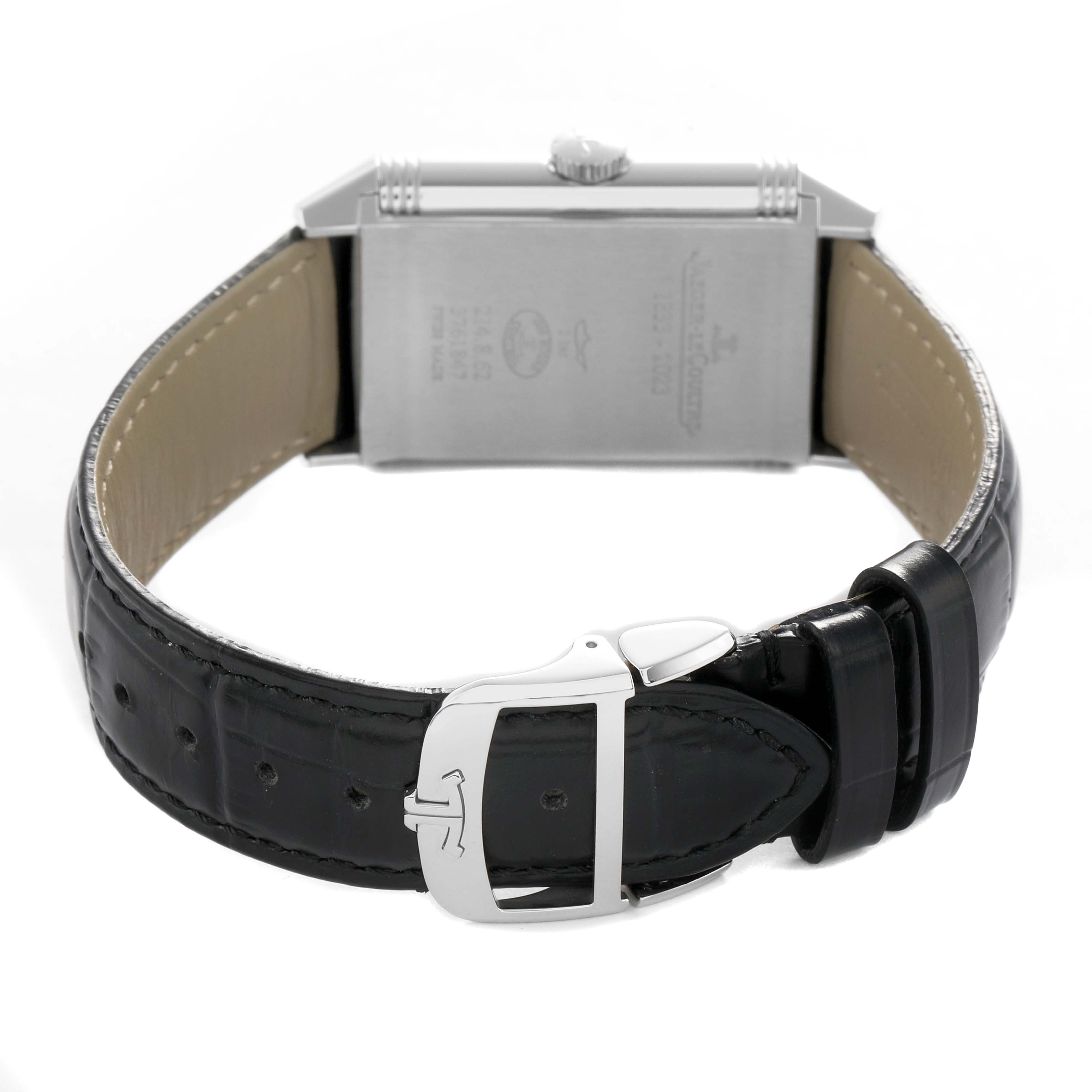 The Jaeger-LeCoultre Reverso watch is shown from the back, highlighting the case back and black leather strap with a silver buckle.