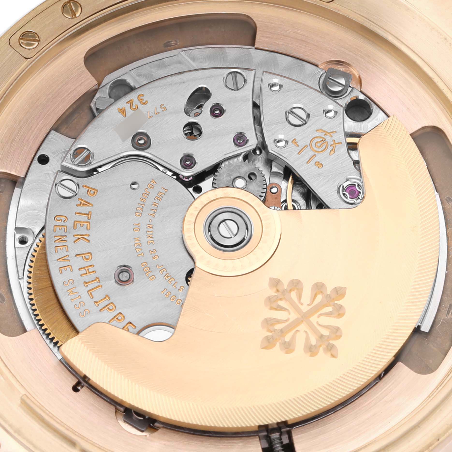 The image shows a close-up of the Patek Philippe Calatrava 5227R-001 Men's Rose Gold Beige Dial's movement.mes
chanism from the back, featuring gears and engravings.