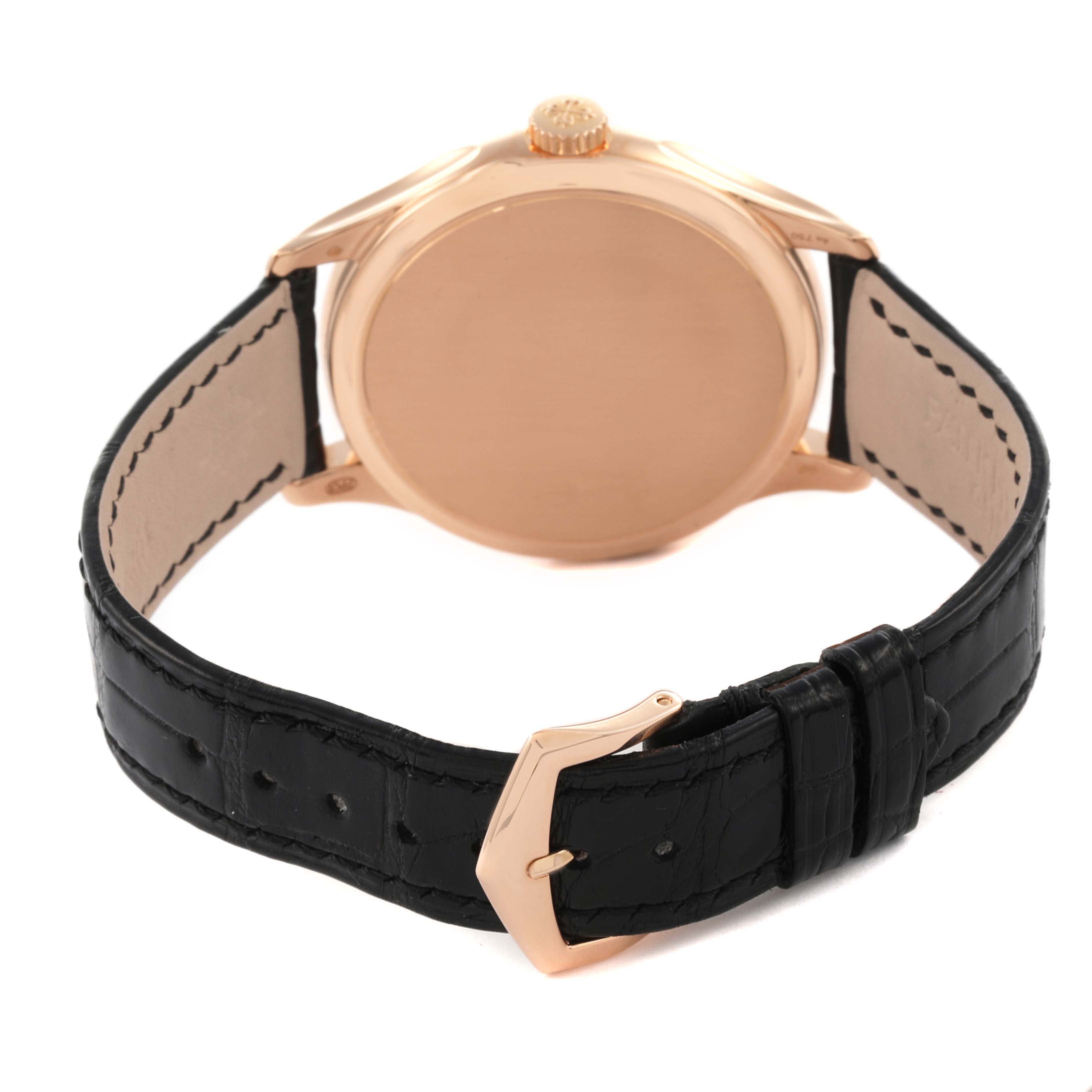 The image shows the back view of a Patek Philippe Calatrava 5227R-001 Men's Rose Gold Champagne Dial 5227R-001 Men's Rose Gold Champagne Dial watch, highlighting the case, crown, and black leather strap with buckle.