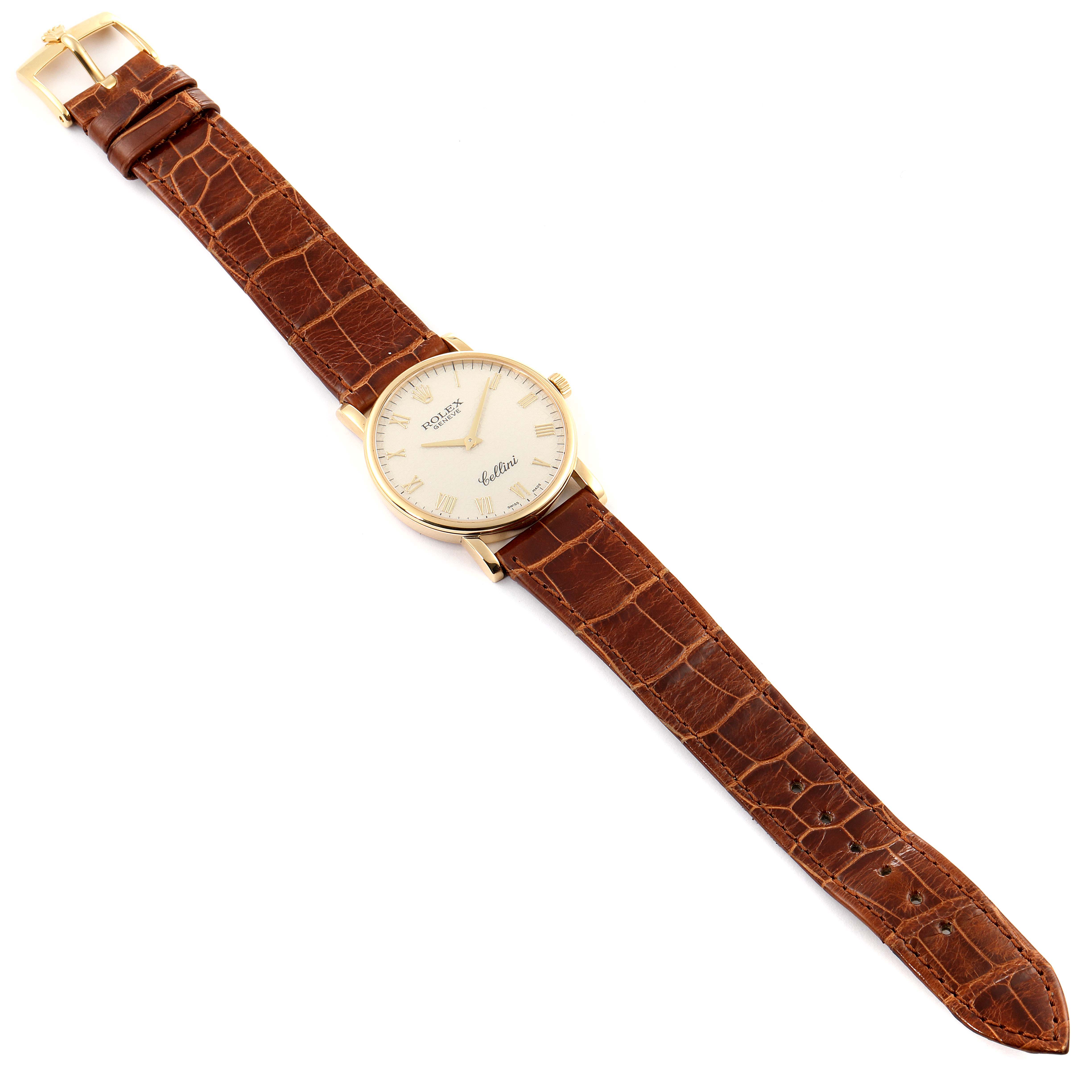 The Rolex Cellini 5115 Men's Yellow Gold Beige Dial 5115 Men's Yellow Gold Beige Dial watch is shown in a top-down angle displaying its face, brown leather strap, and buckle.