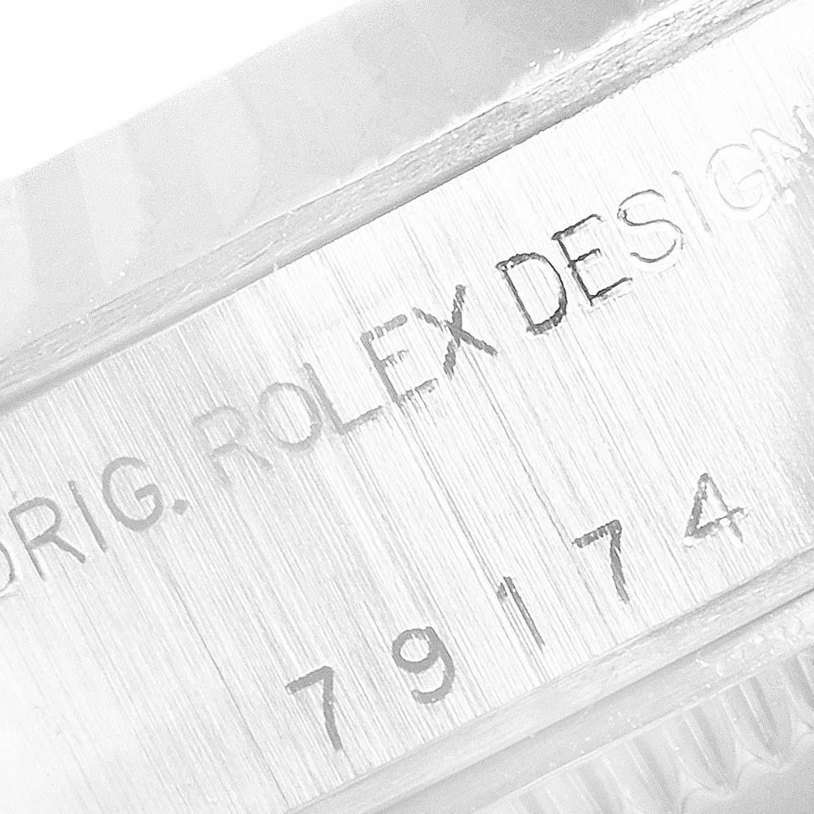 This close-up image of a Rolex Datejust 79174 Women's Stainless Steel Mother of Pearl Dial 79174 Women's Stainless Steel Mother of Pearl Dial watch shows the etched model number and part of the bezel.