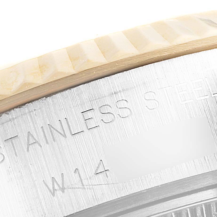 This close-up image shows the bezel and part of the casing of a Rolex Datejust 69173 Women
s Steel and Gold (two tone) Champagne Dial 69173 Women
s Steel and Gold (two tone) Champagne Dial model, with "STAINLESS STEEL" engraved.