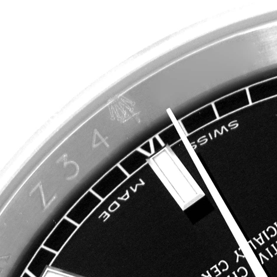 The image shows a close-up of the Rolex Datejust 116200 Men's Stainless Steel Black Dial 116200 Men's Stainless Steel Black Dial's dial and bezel, featuring the hour markers and part of the seconds hand.