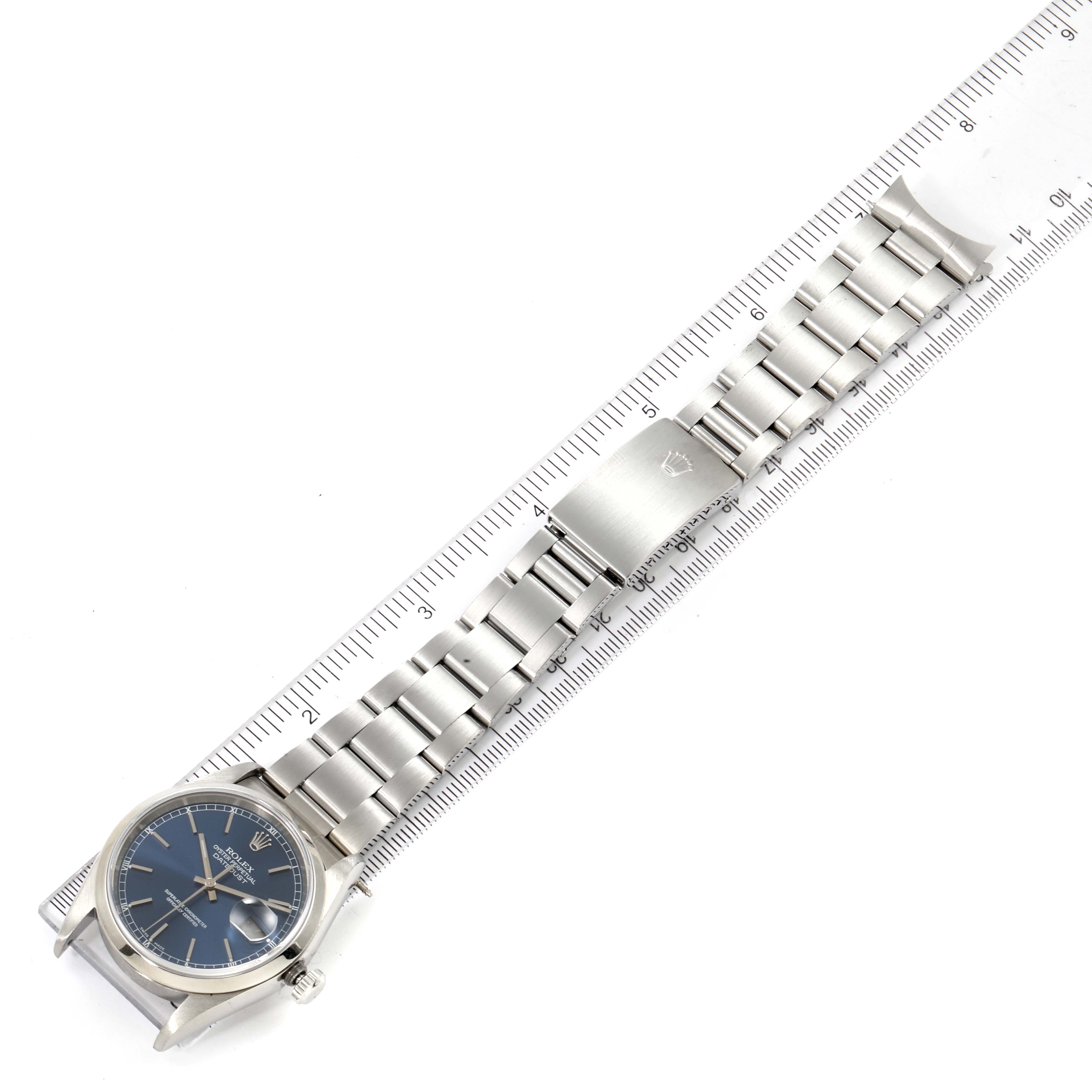 This image shows a top-down angle of the Rolex Datejust 16200 Men's Stainless Steel Blue Dial 16200 Men's Stainless Steel Blue Dial watch, including its bracelet and case placed alongside a ruler.