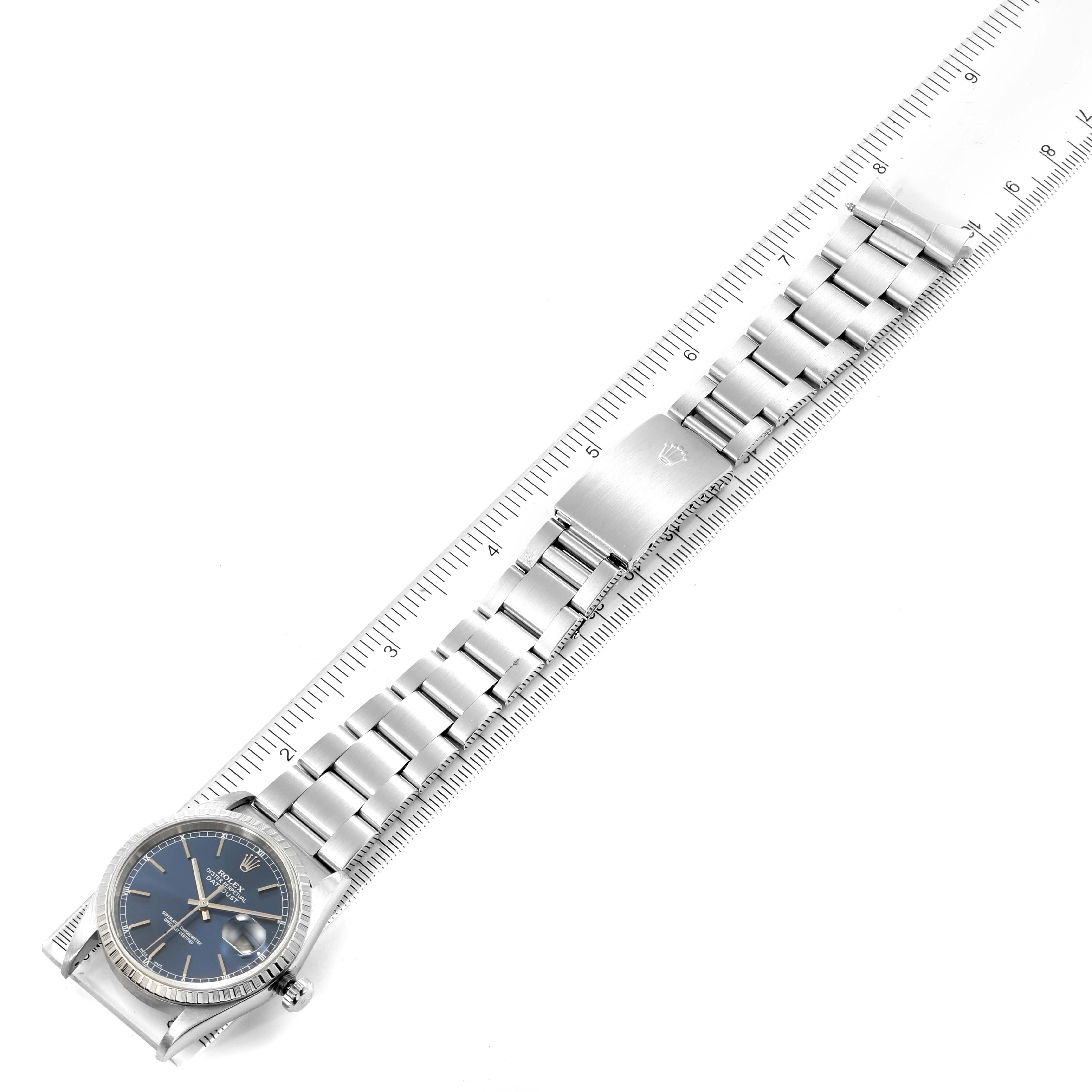 The image shows a Rolex Datejust 16220 Men's Stainless Steel Blue Dial 16220 Men's Stainless Steel Blue Dial watch positioned alongside a ruler, displaying the full length of its band and clasp.