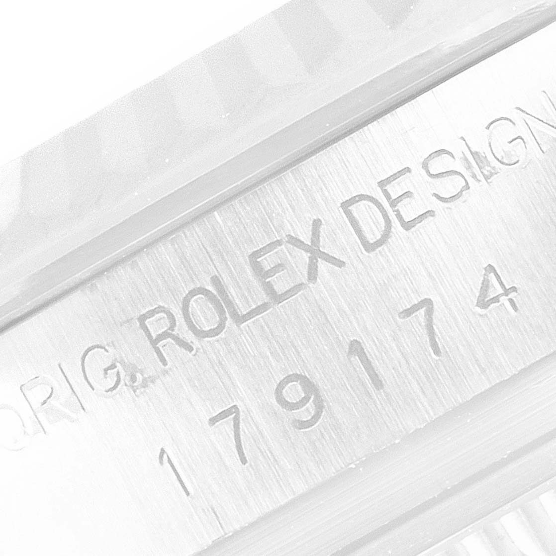 The image shows a close-up of the Rolex Datejust 179174 Women's Stainless Steel Silver Dial 179174 Women's Stainless Steel Silver Dial model's case, displaying the engraving "ROLEX DESIGN" and part of the serial number.