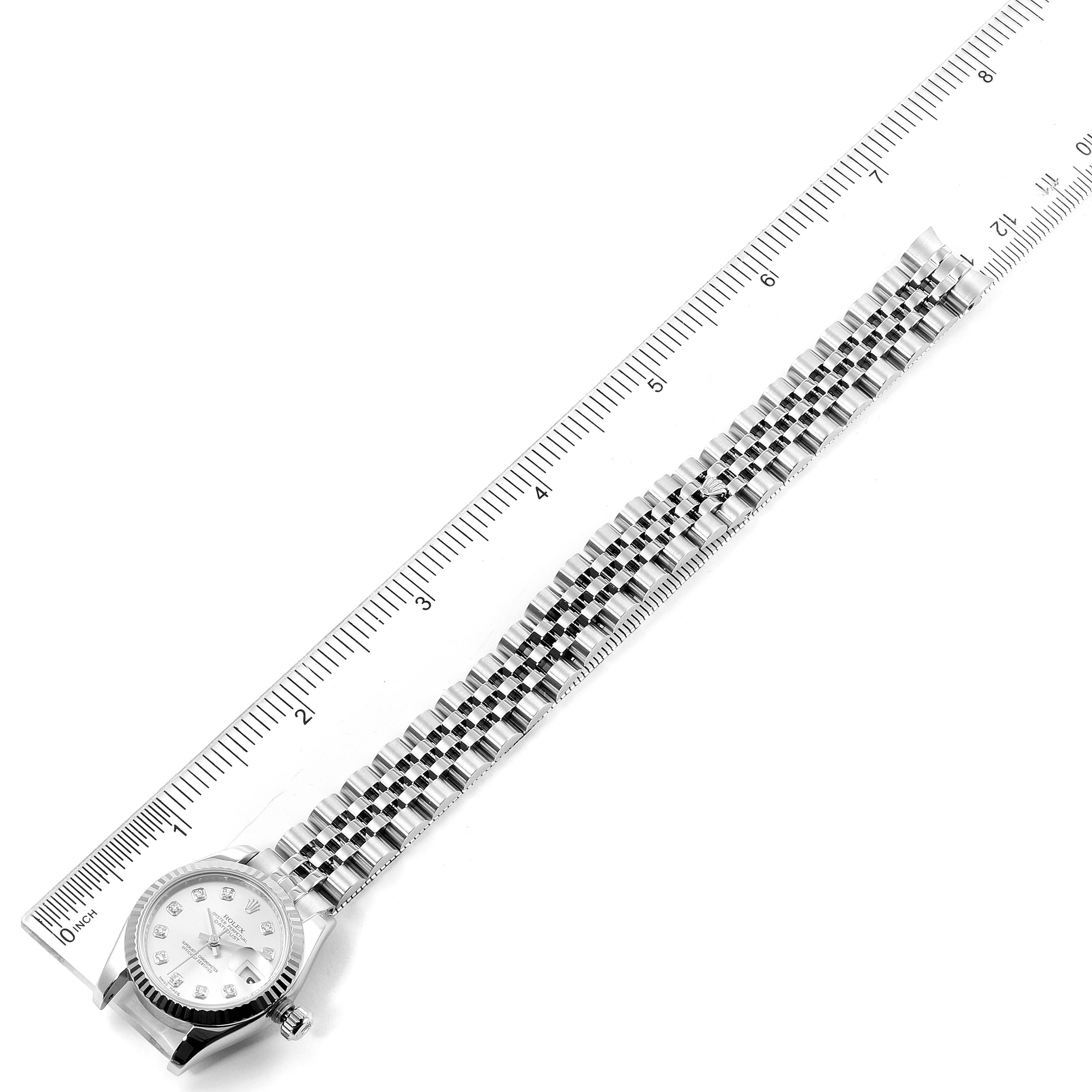 The Rolex Datejust 179174 Women's Stainless Steel Silver Dial 179174 Women's Stainless Steel Silver Dial watch is shown flat with its face and bracelet, alongside a ruler for scale.