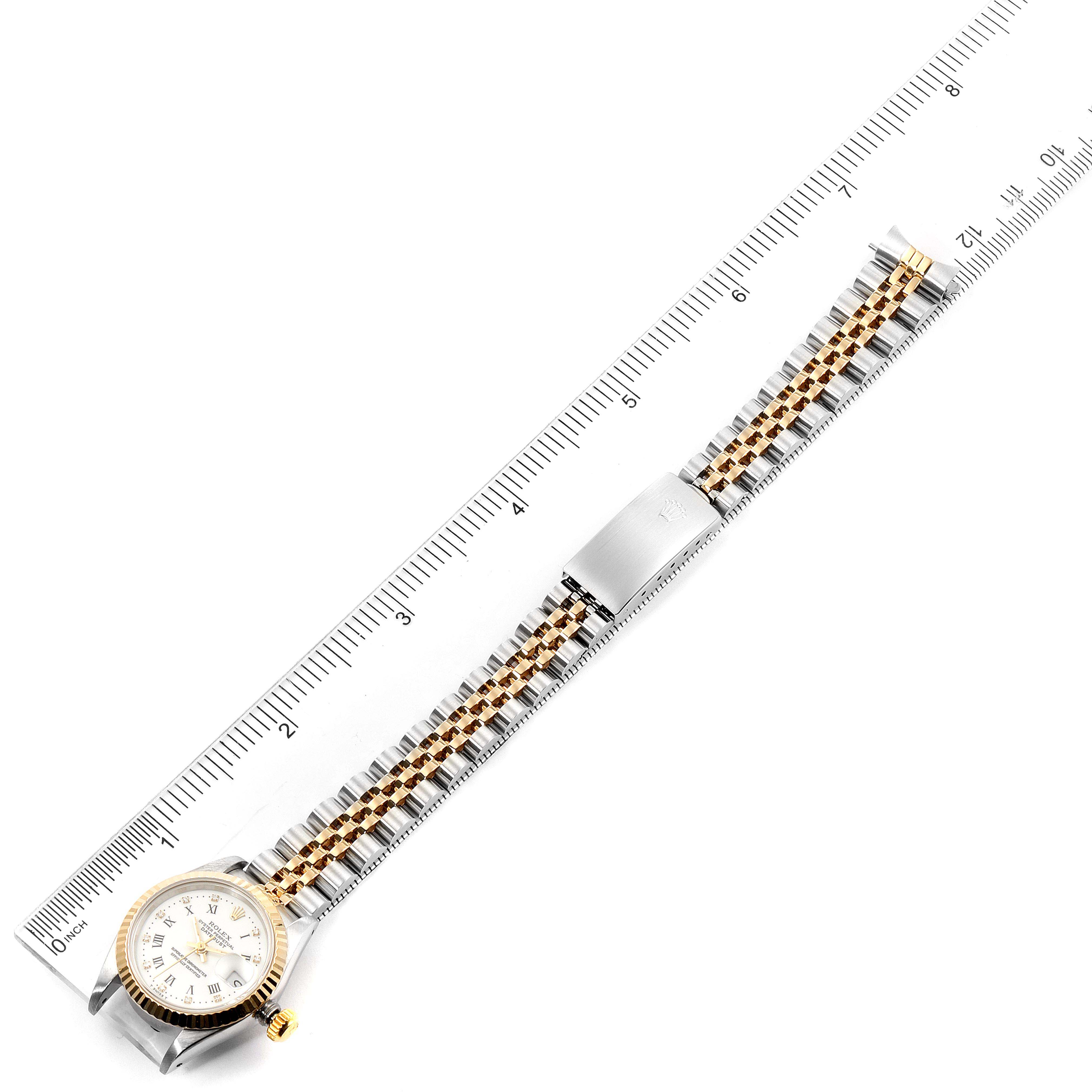 The Rolex Datejust 69173 Women's Steel and Gold (two tone) White Dial 69173 Women's Steel and Gold (two tone) White Dial watch is shown from a top-down angle with a ruler, displaying its face and entire bracelet.