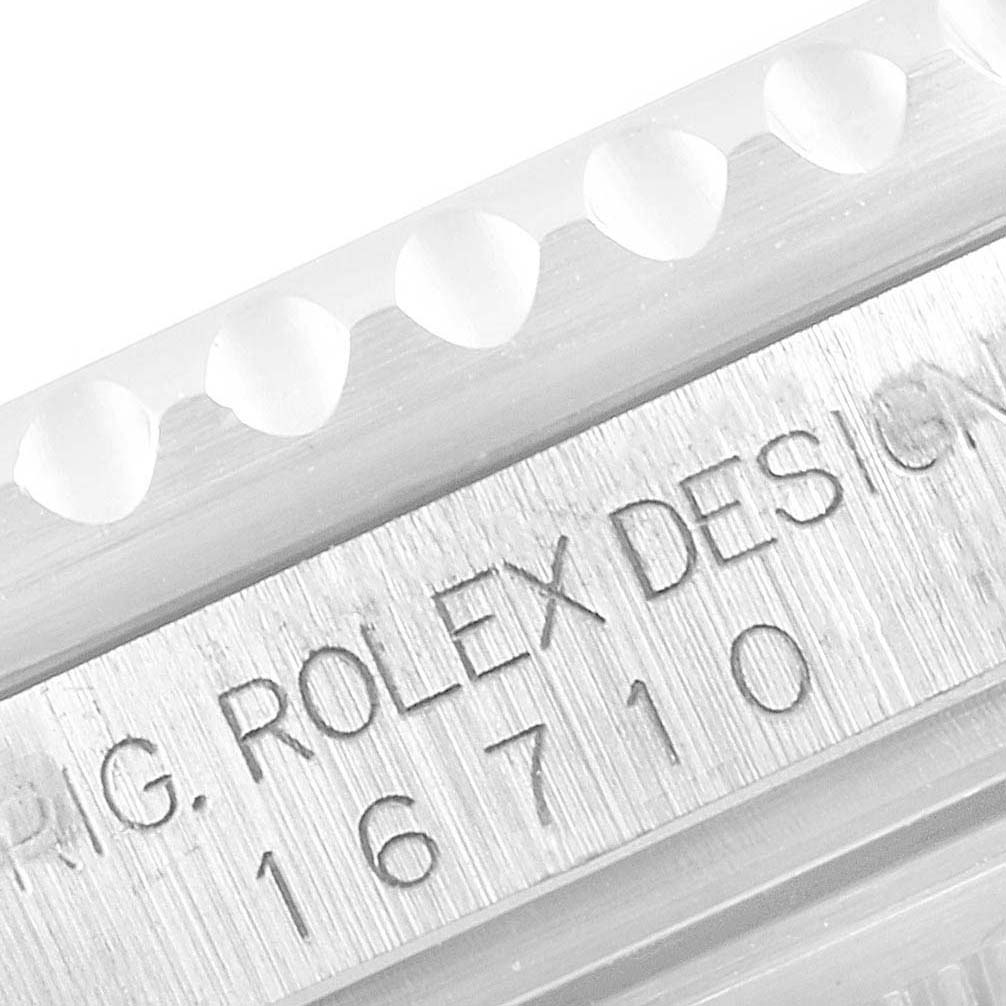 The image shows a close-up of the case edge of a Rolex GMT-Master 16710 Men
s Stainless Steel Black Dial 16710 Men
s Stainless Steel Black Dial model, revealing the engraved design number 
16710
.