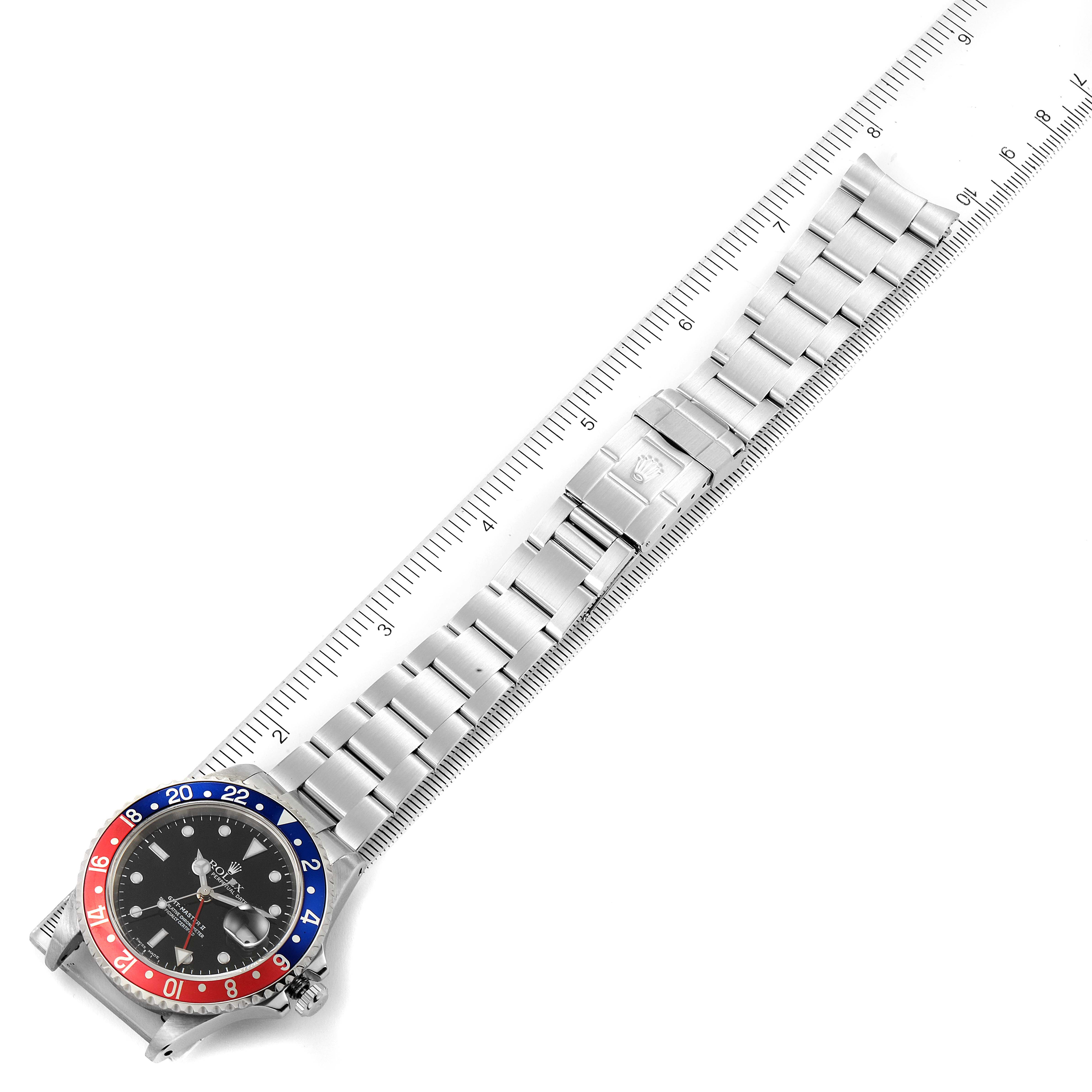 The image shows a Rolex GMT-Master 16710 Men
s Stainless Steel Black Dial 16710 Men
s Stainless Steel Black Dial watch with a ruler measuring its full bracelet length from an overhead angle.