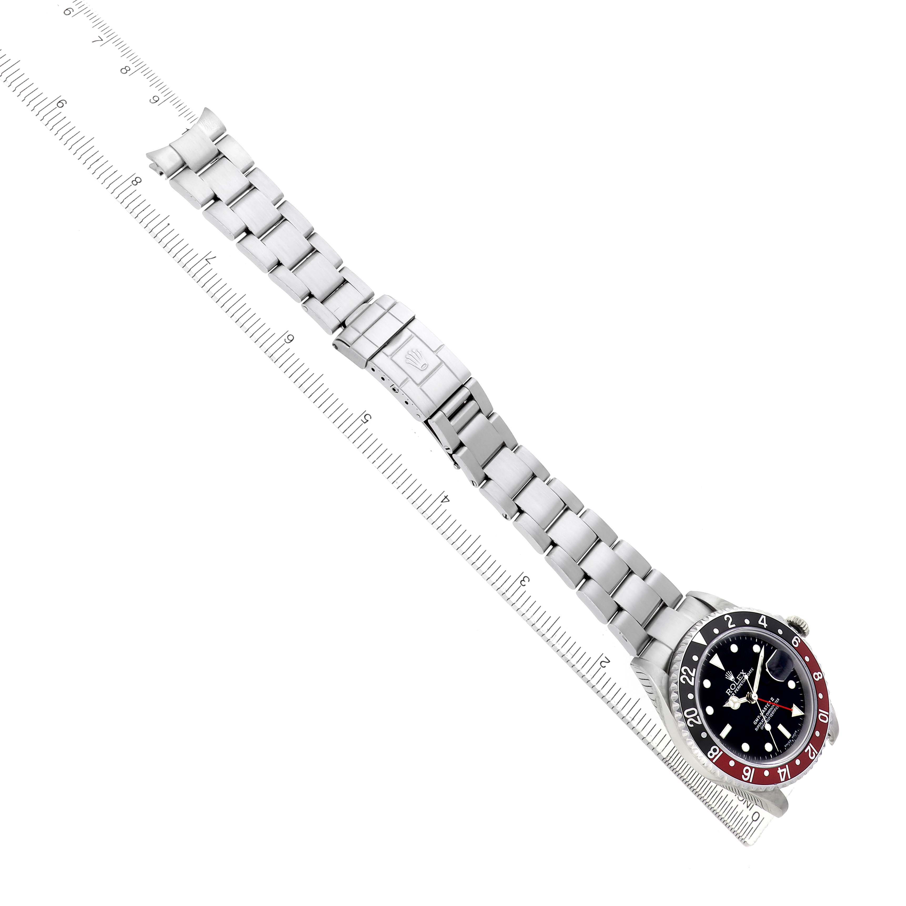 The Rolex GMT-Master 16710 Men's Stainless Steel Black Dial watch is displayed diagonally, showing the dial, bezel, bracelet, and clasp alongside a ruler.