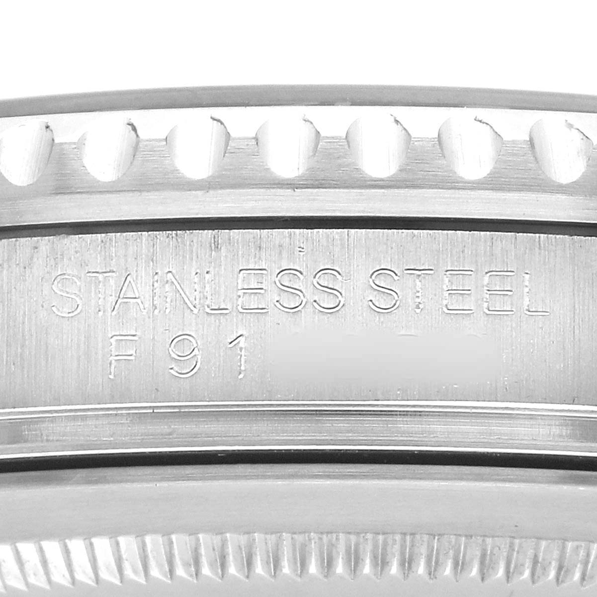 The image shows a close-up of the side of a Rolex GMT-Master 16710 Men's Stainless Steel Black Dial watch, highlighting the stainless steel bezel with engraved text.